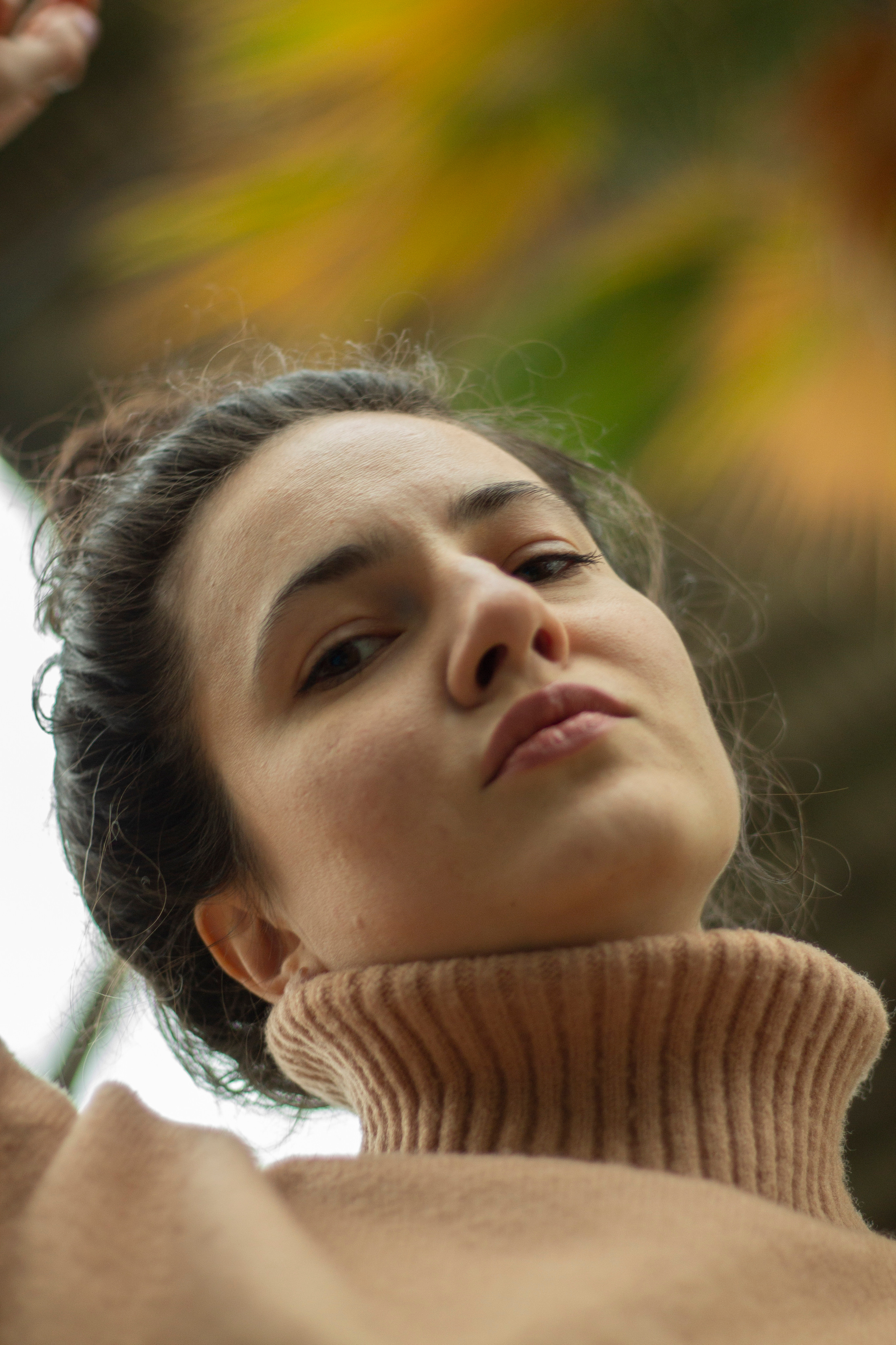 Девушка с собранными волосами смотрит на нас свысока