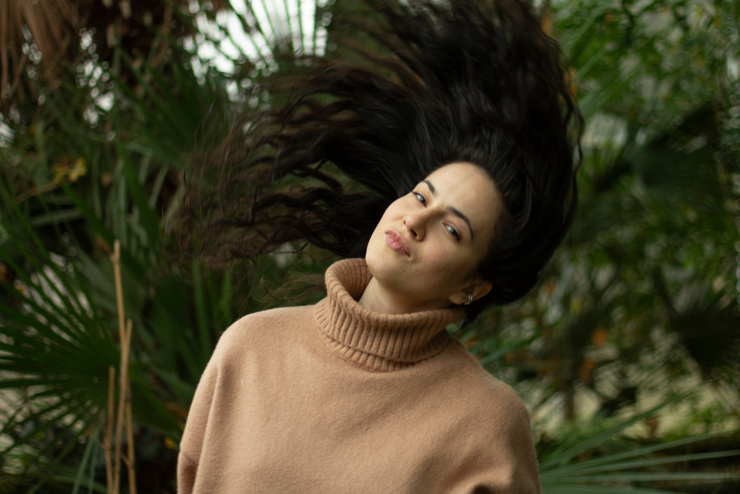 Темные кудрявые волосы летят во все стороны в оранжерее фотограф Анна Карамурзина