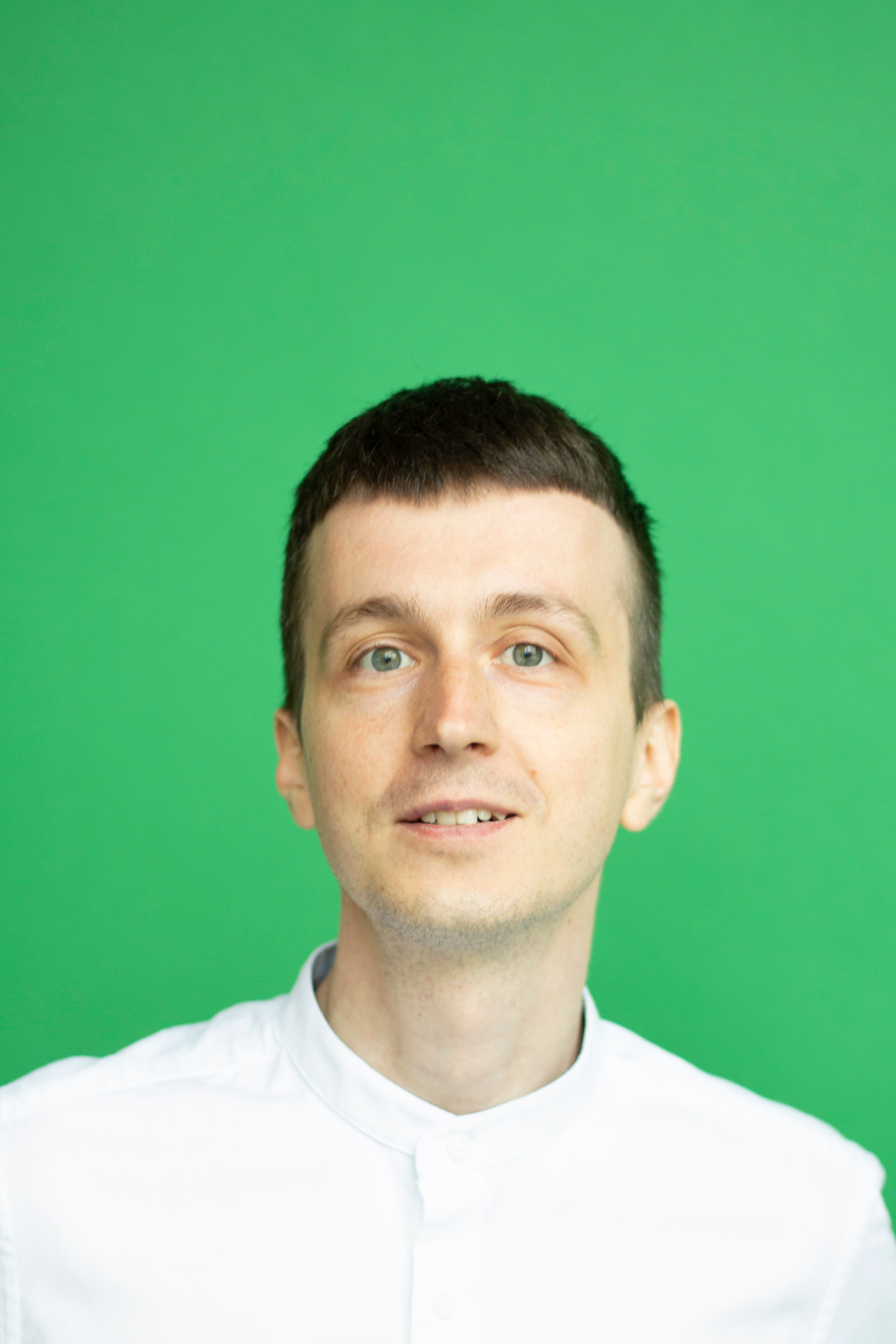 Парень в белой рубашке на зеленом фоне 