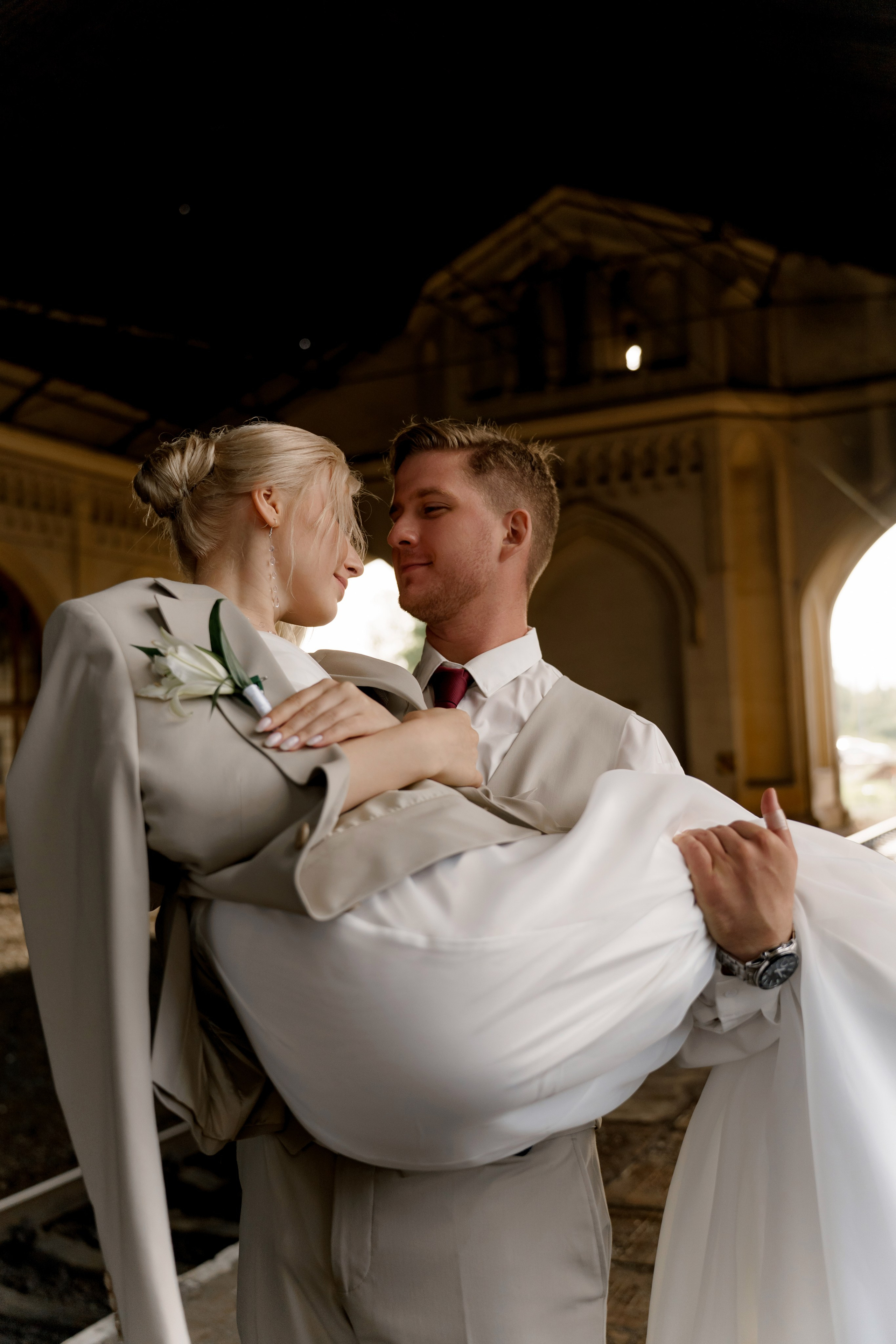 Свадьба в Санкт-Петербурге, фотосессия на прогулке, жених несет невесту на руках на вокзале.