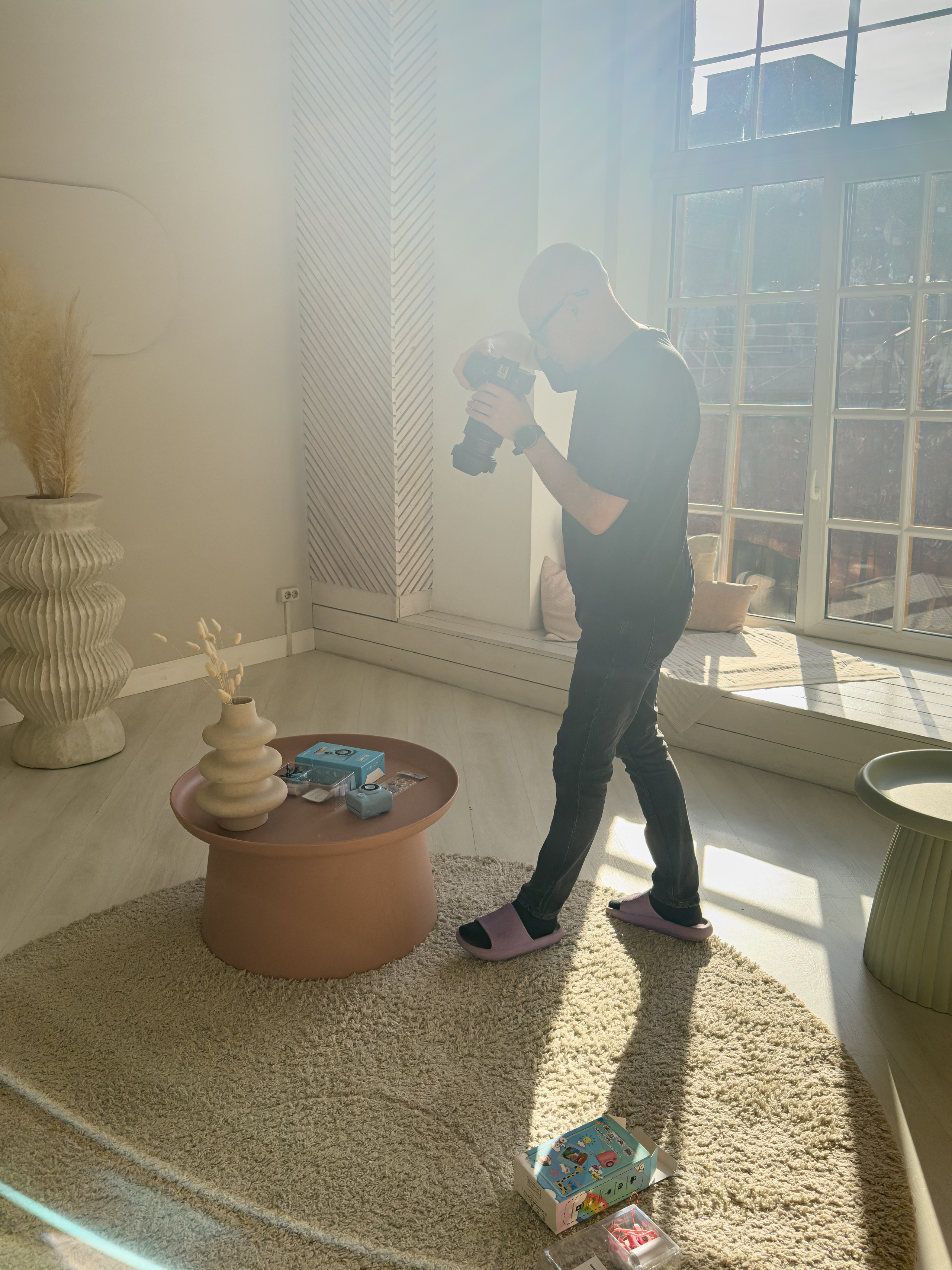 Фотограф проводит предметную фотосъёмку в интерьерной фотостудии