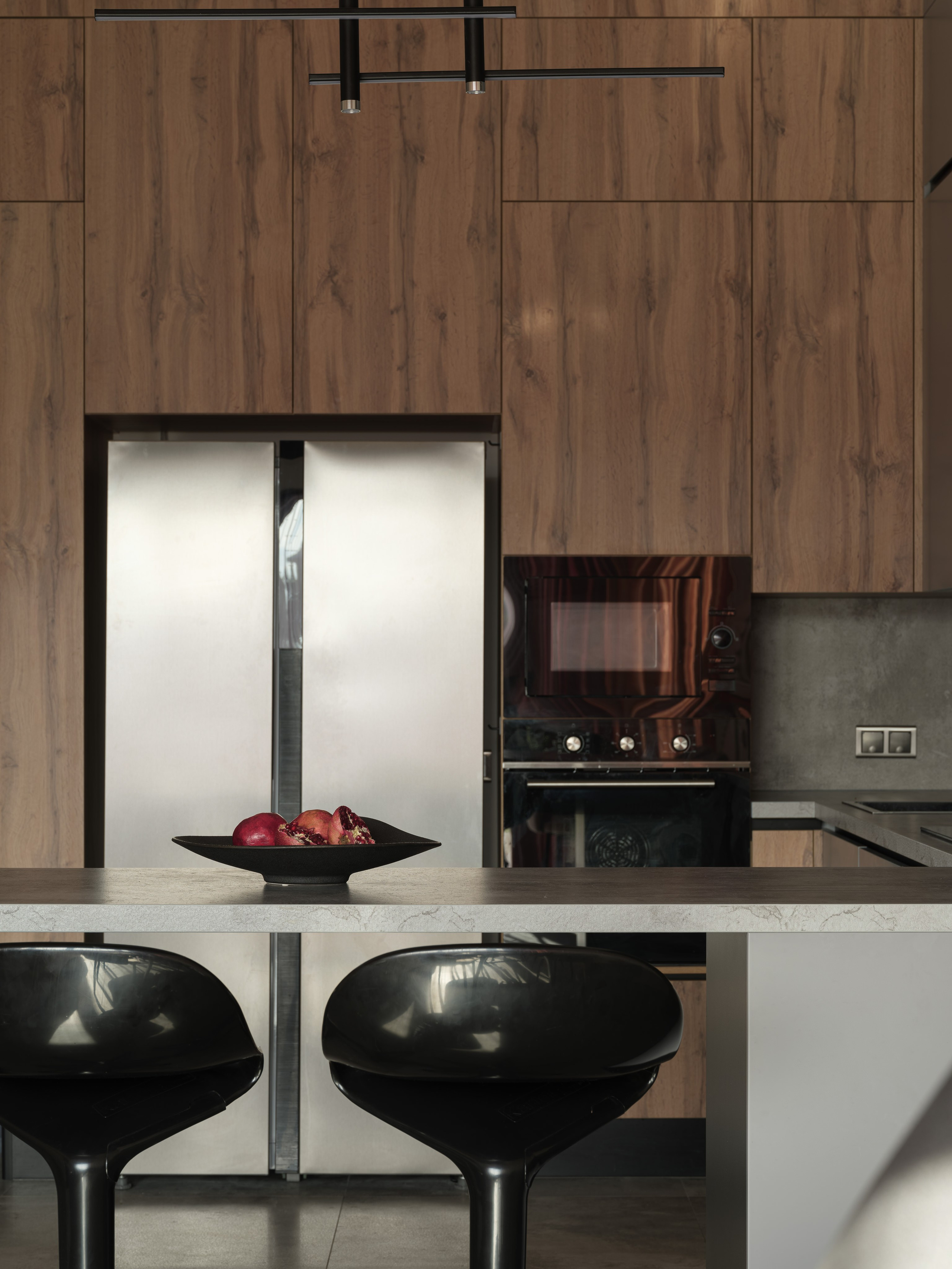 Интерьер кухни с островом, фасадами под натуральное дерево и современным освещением. Баланс тепла и строгости — работа дизайнера Алины Дёровой, стилиста Натальи Якушевой, фотографа Сергея Денисенко, подчеркнувшего линии и фактуры.