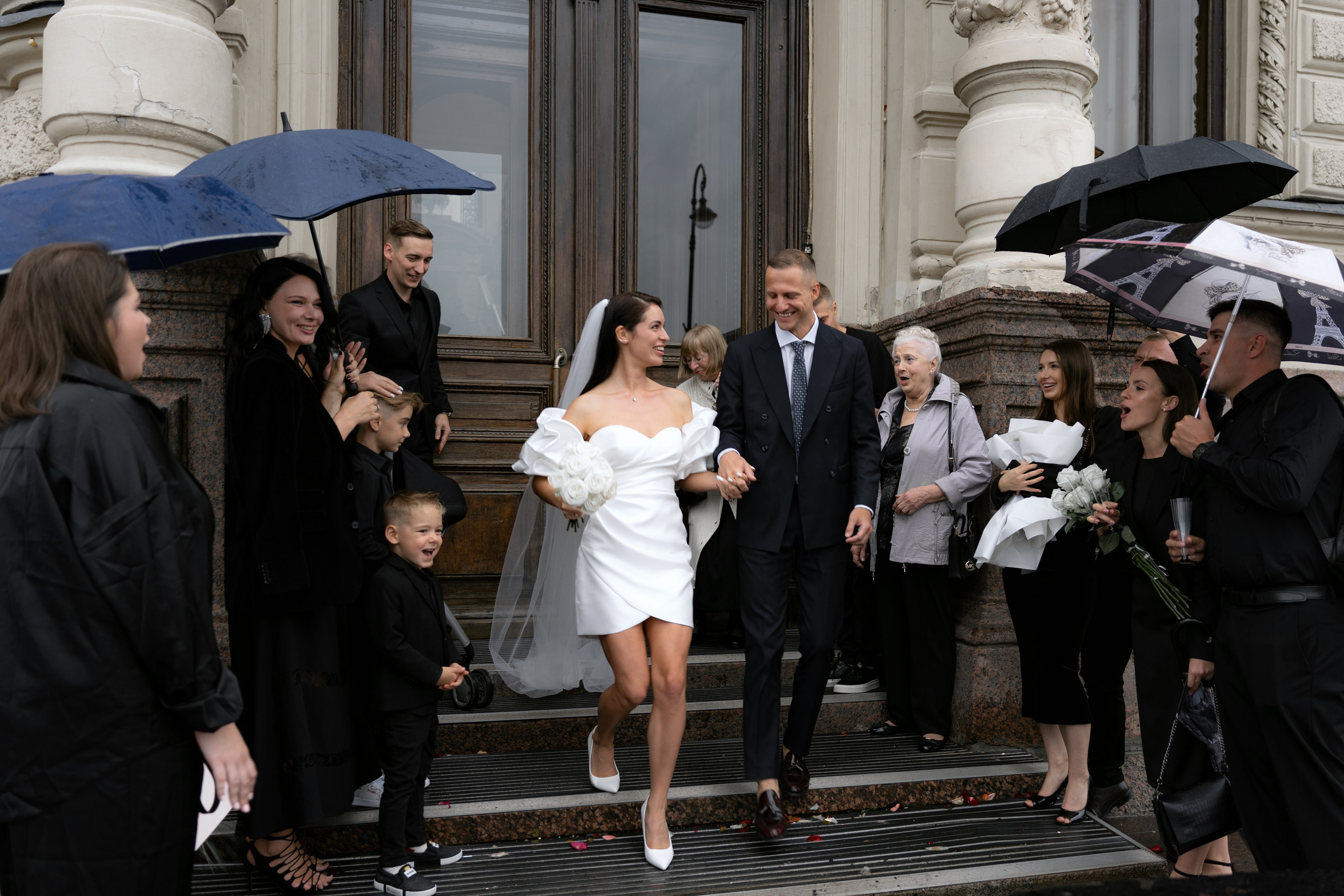Невеста выходит из дворца бракосочетания №1 под аплодисменты гостей в Санкт-Петербурге