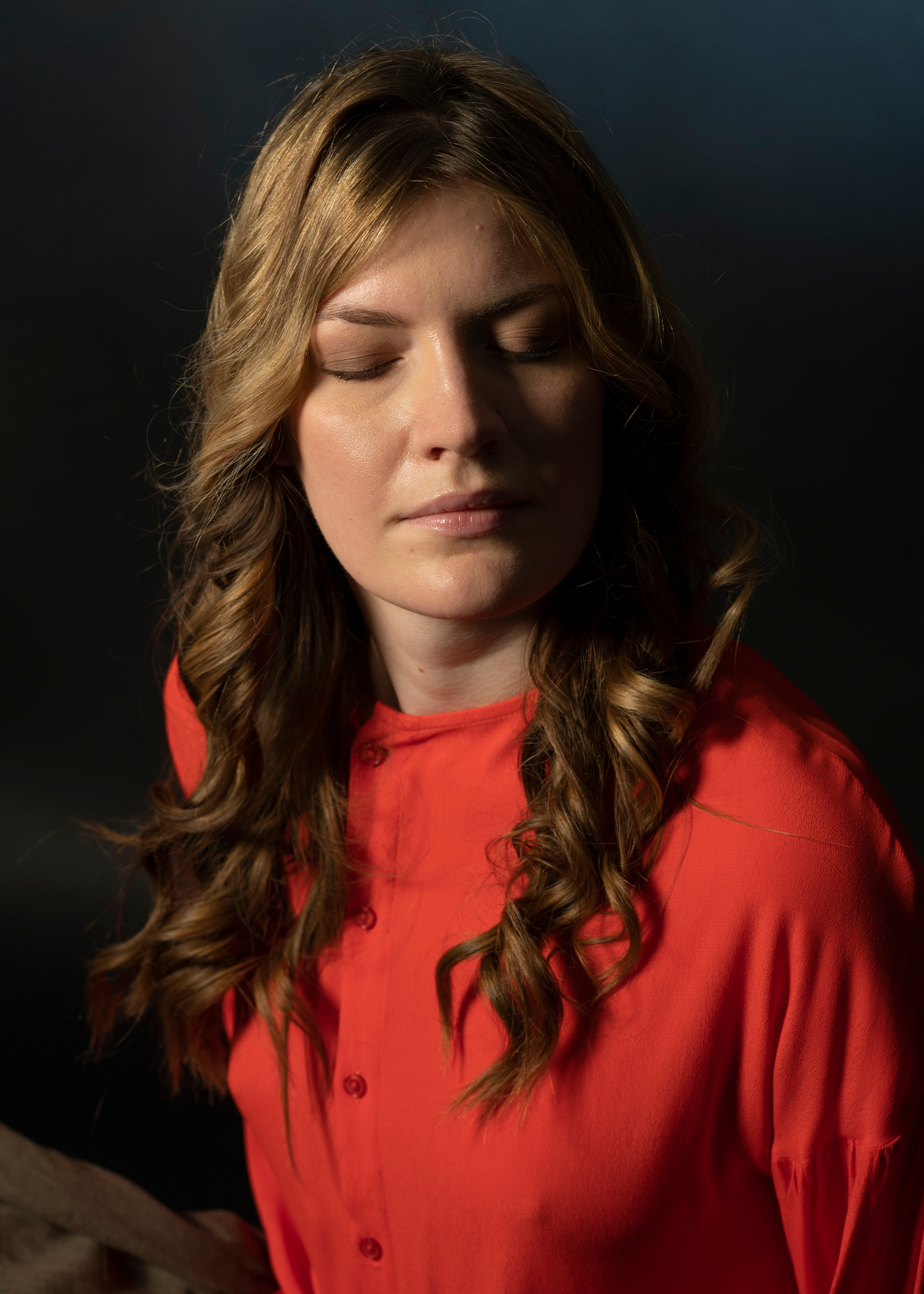 Портретная съёмка красивой девушки в красном в студии