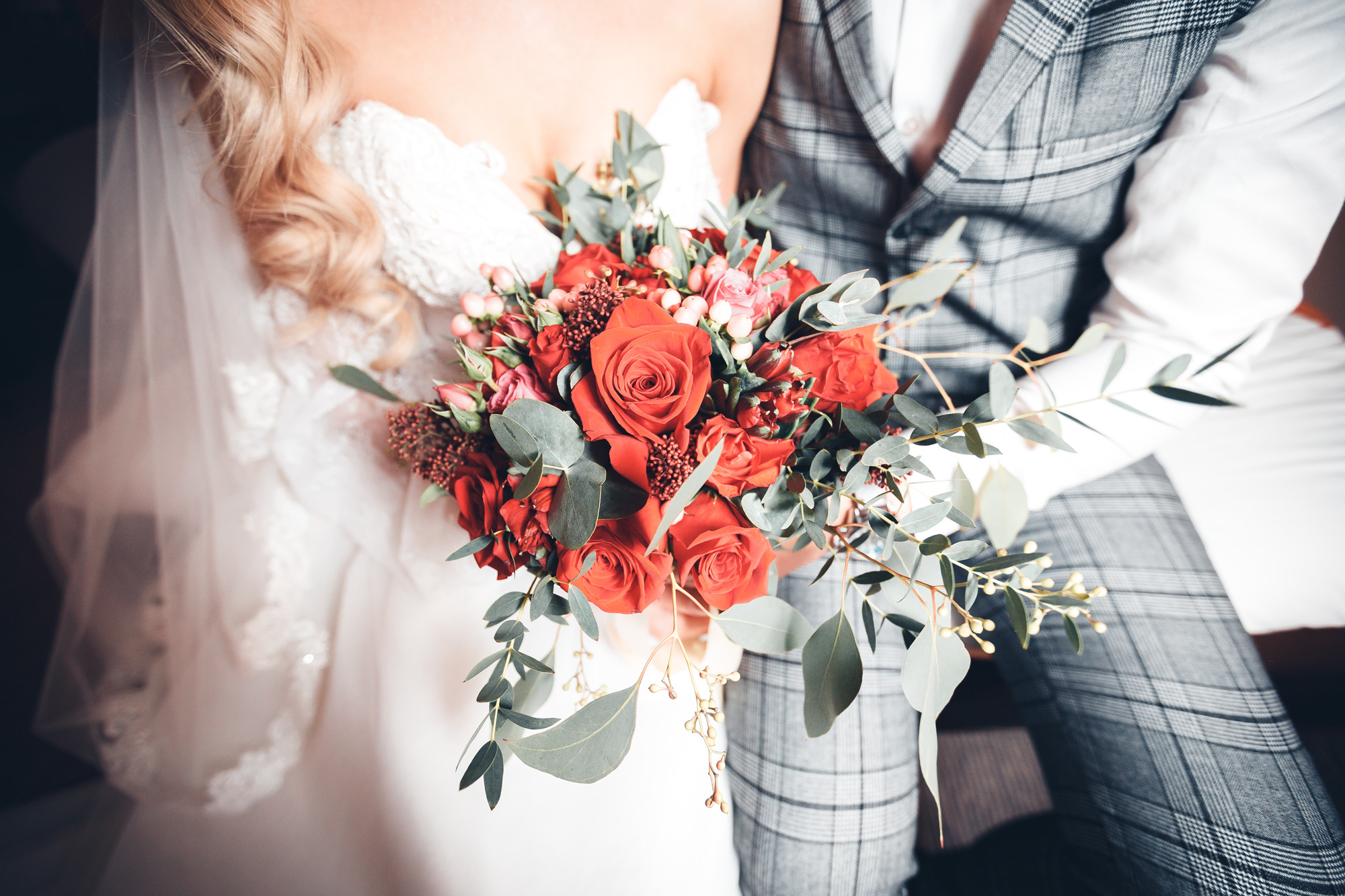 Фотография свадебного букета и молодоженов