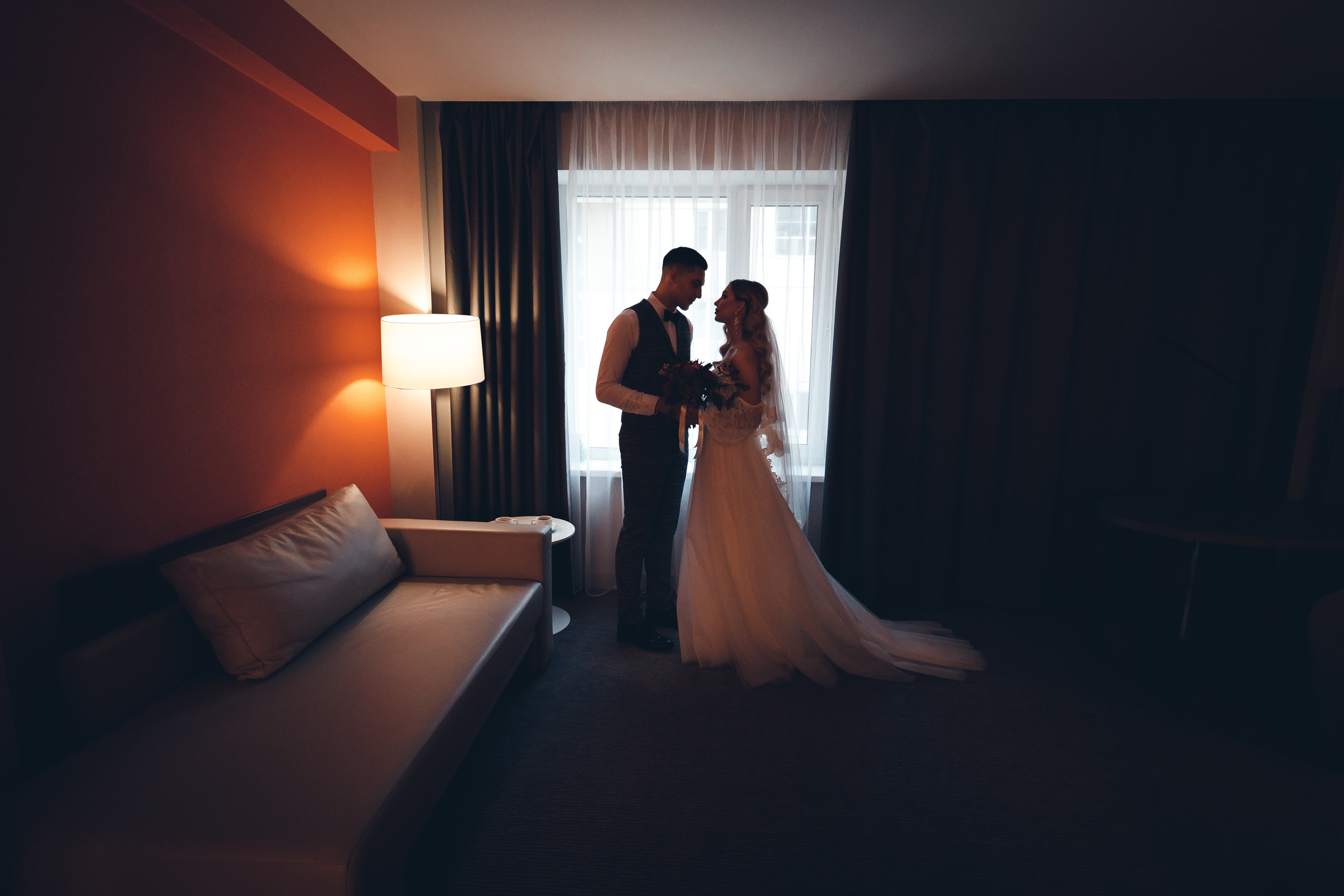 Общий  портрет жениха и невесты в номере отеля на свадьбе