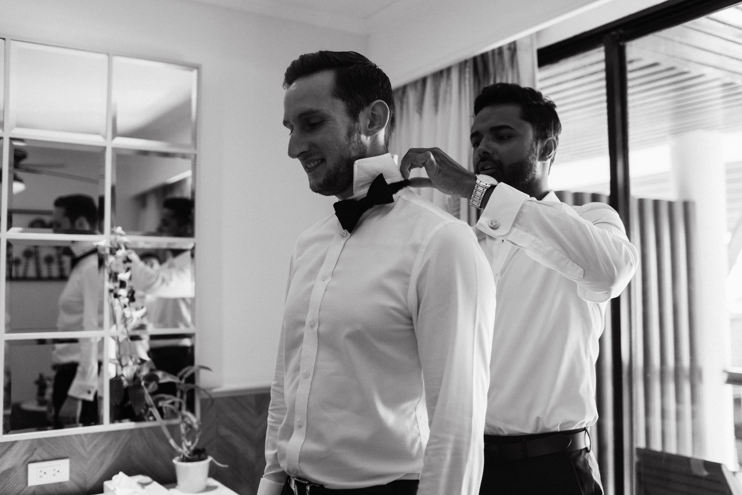 дуг жениха одевает бабочку