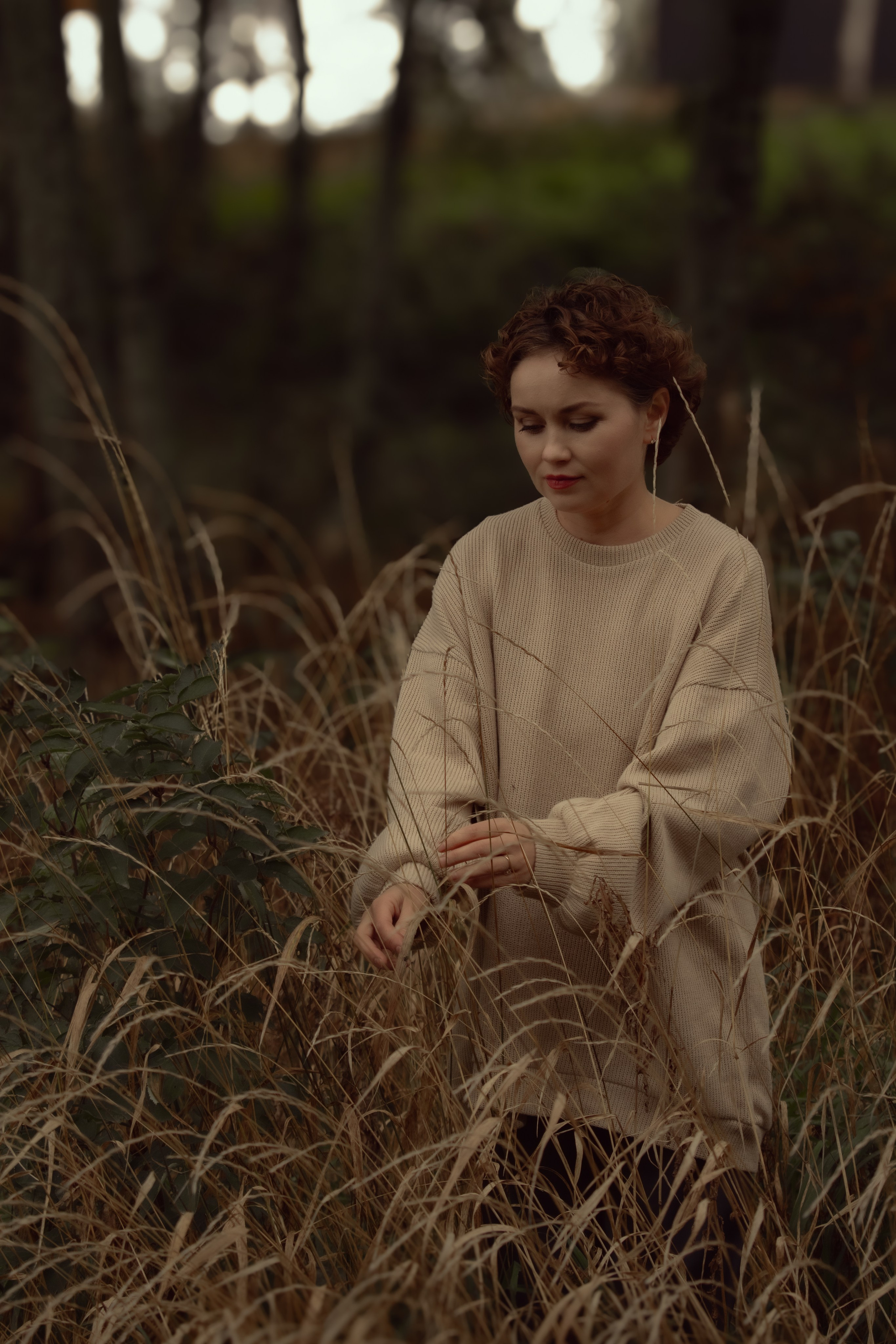 Девушка в свитере гуляет в траве