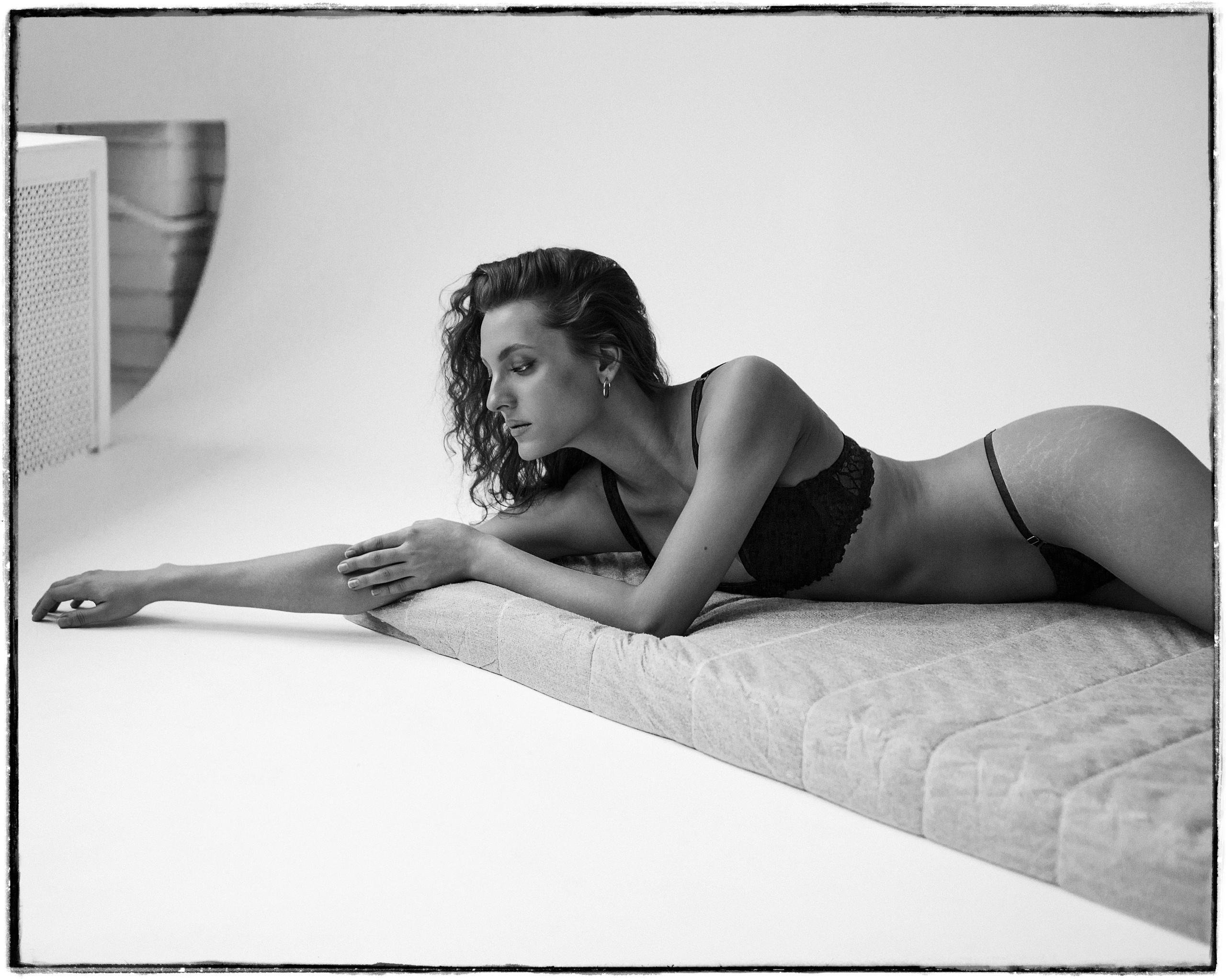 Красивая девушка лежит на матрасе.