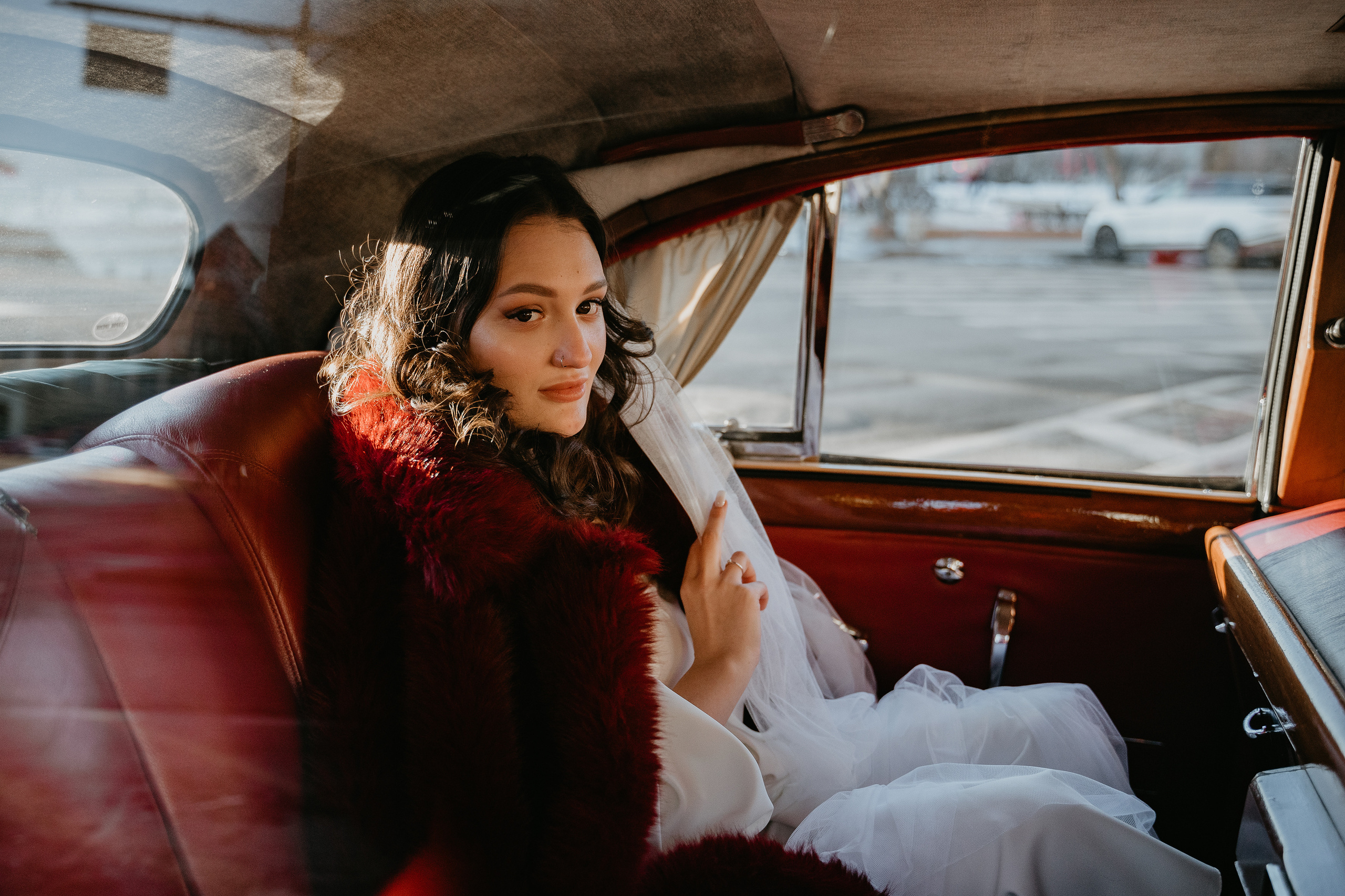 невеста в бордовой шубе в ретро автомобиле