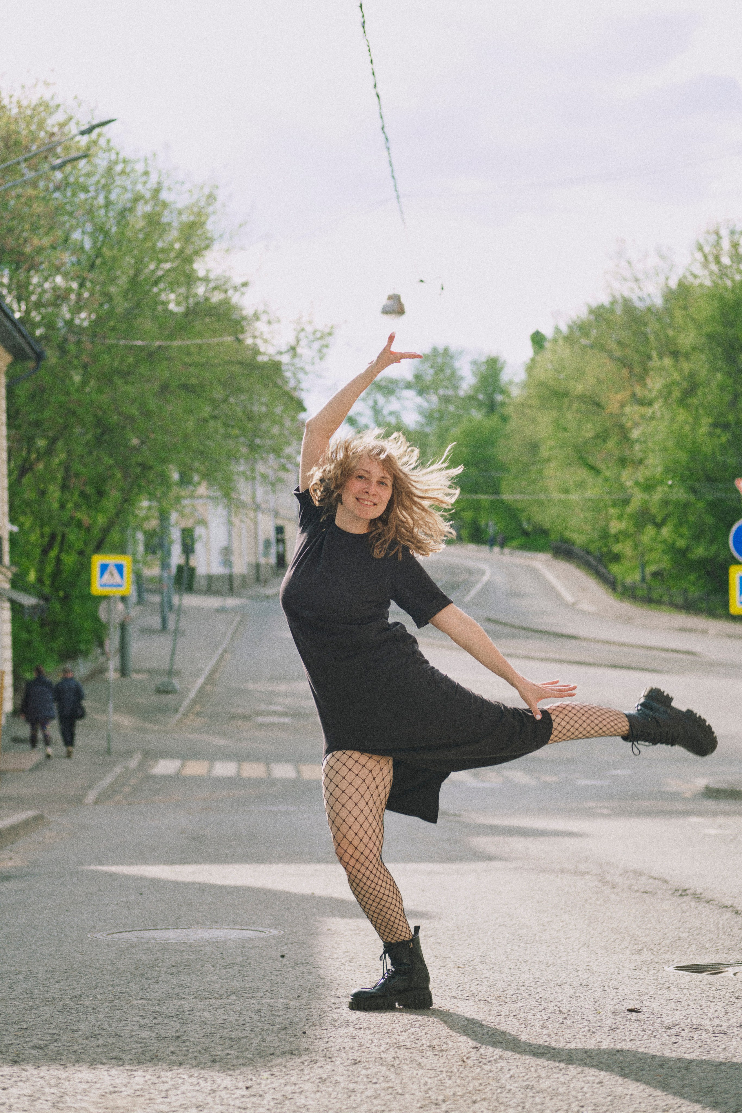 Женщина в прыжке на фоне старой трамвайной улицы