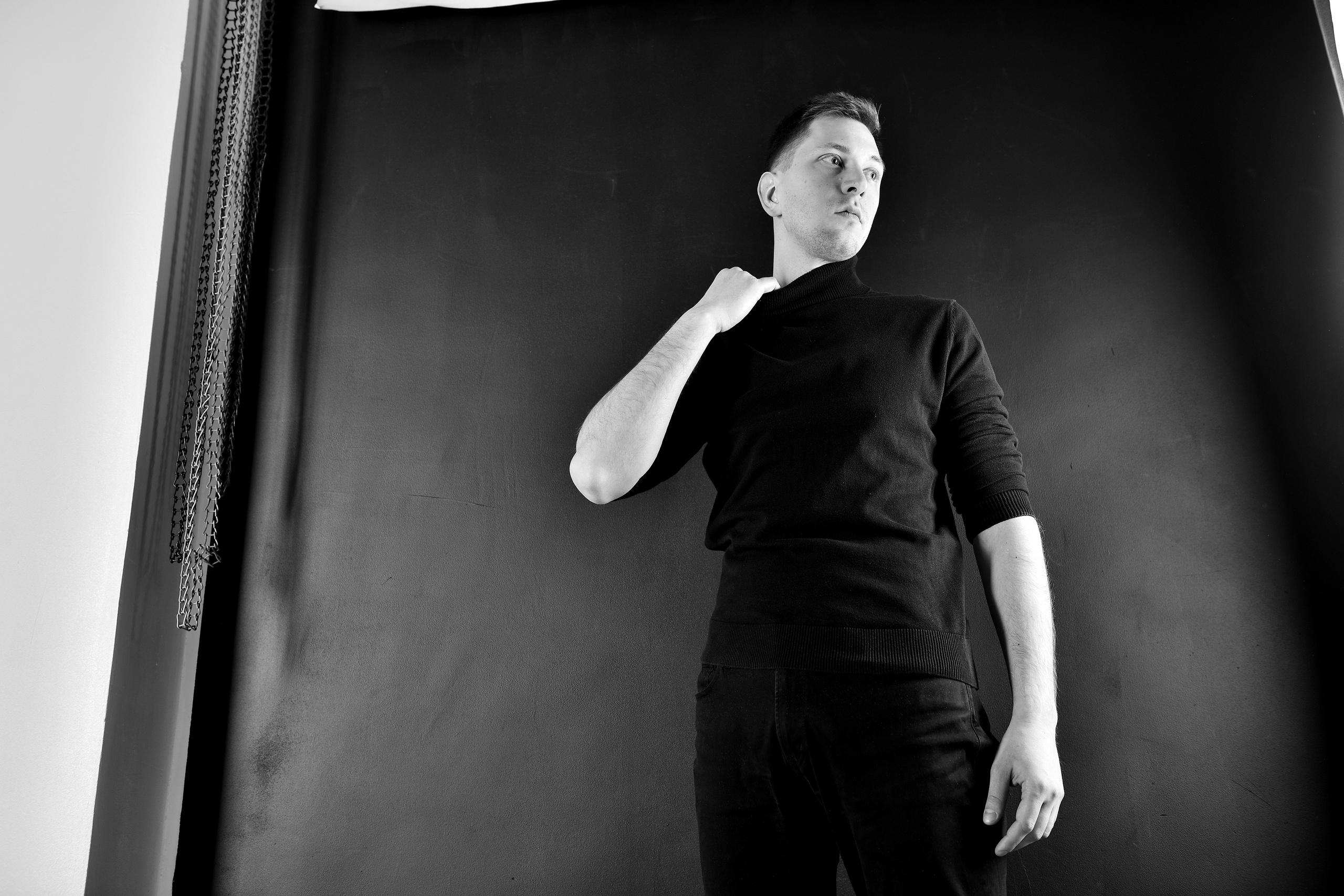 Портрет юноши на черном фоне в студии.