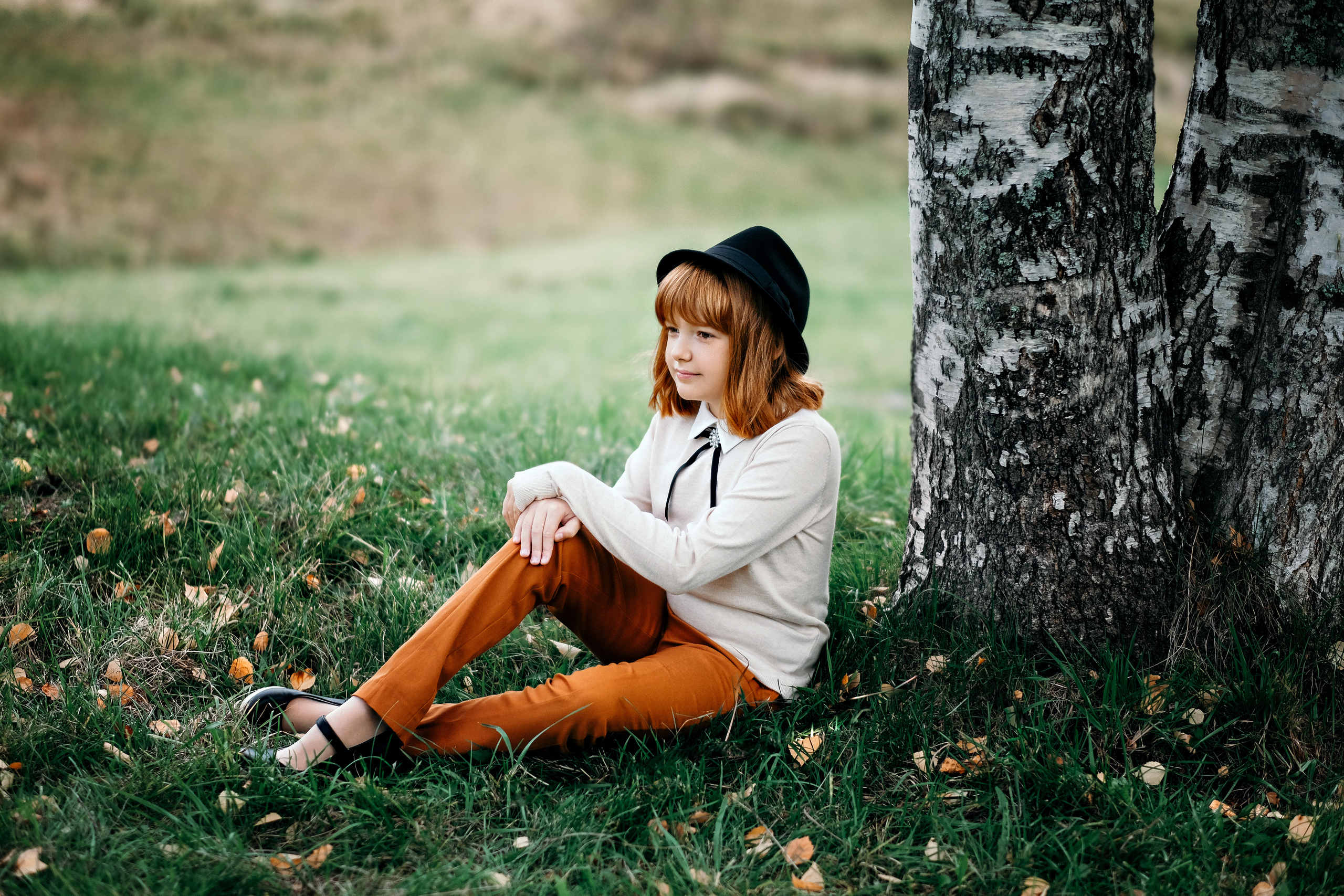 рыжая девочка в рыжих штанах у березы в туристическом комплексе Малые КАРЕЛЫ  на траве
