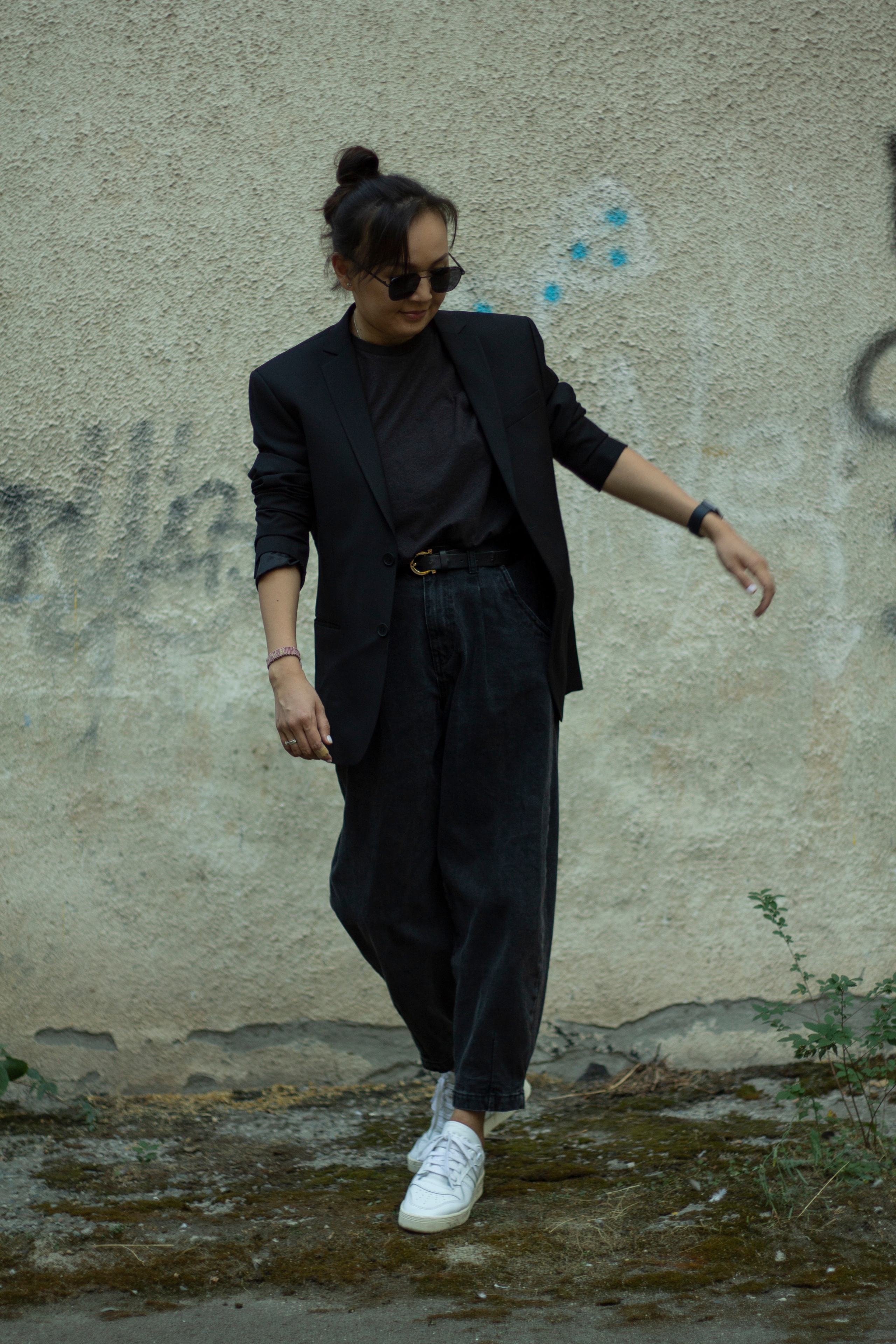 Girl in the black suit near wall