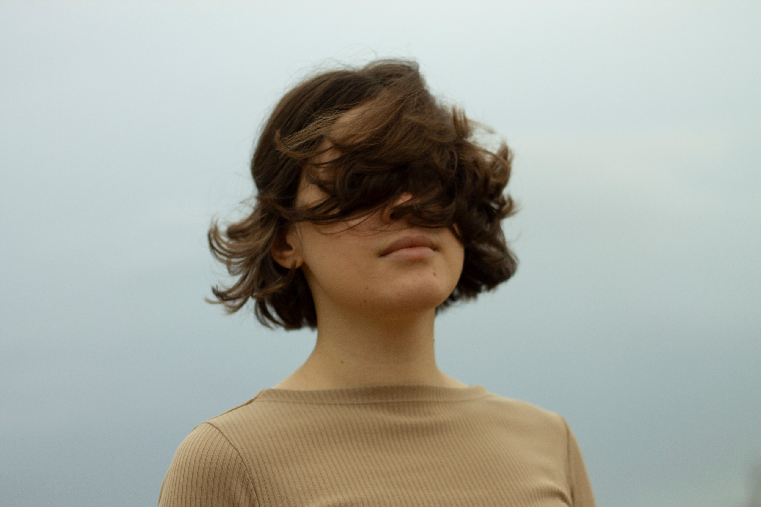 girl shaking her hain on the grey background by Anna Karamurzina