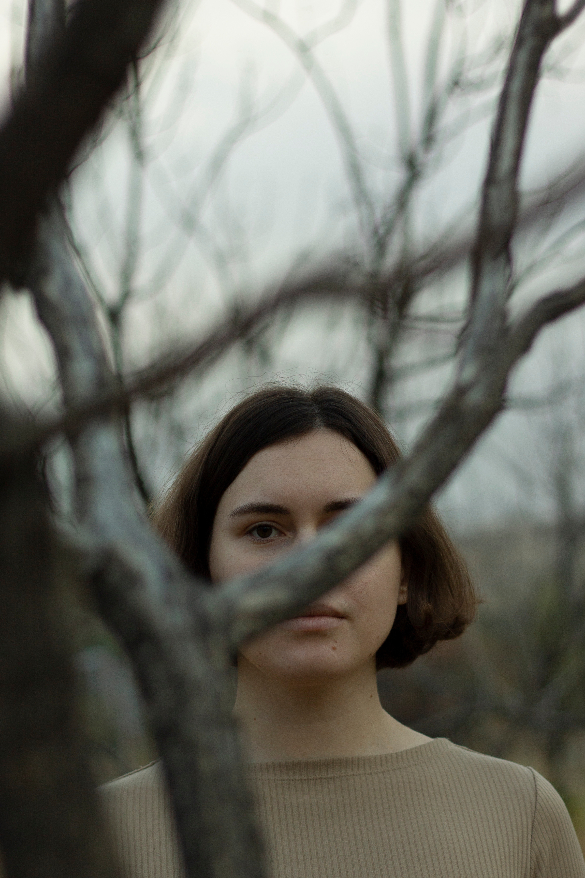 woman in the cold fead forest in grey colours by Anna Karamurzina