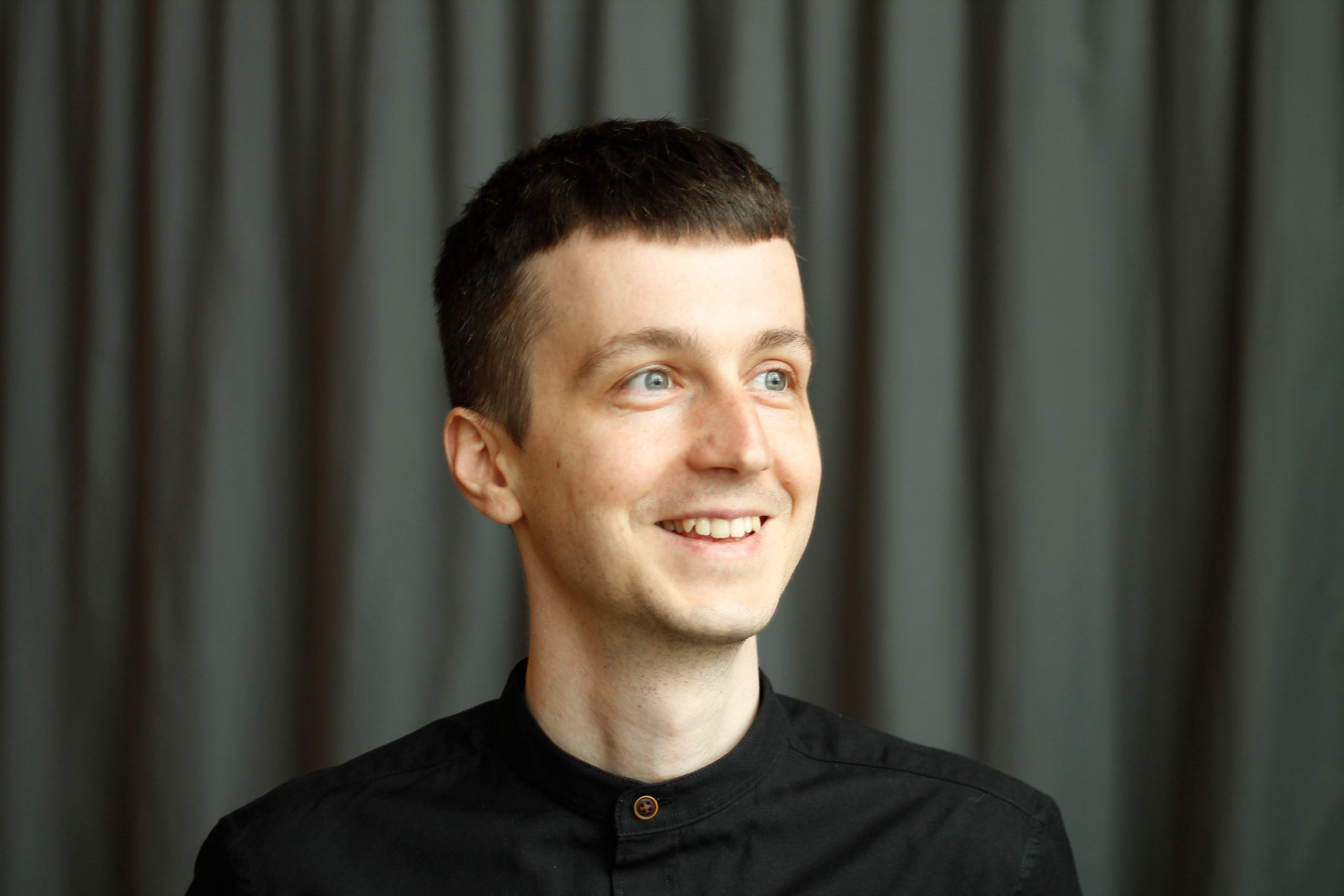 Man portrait in black shirt on the grey background