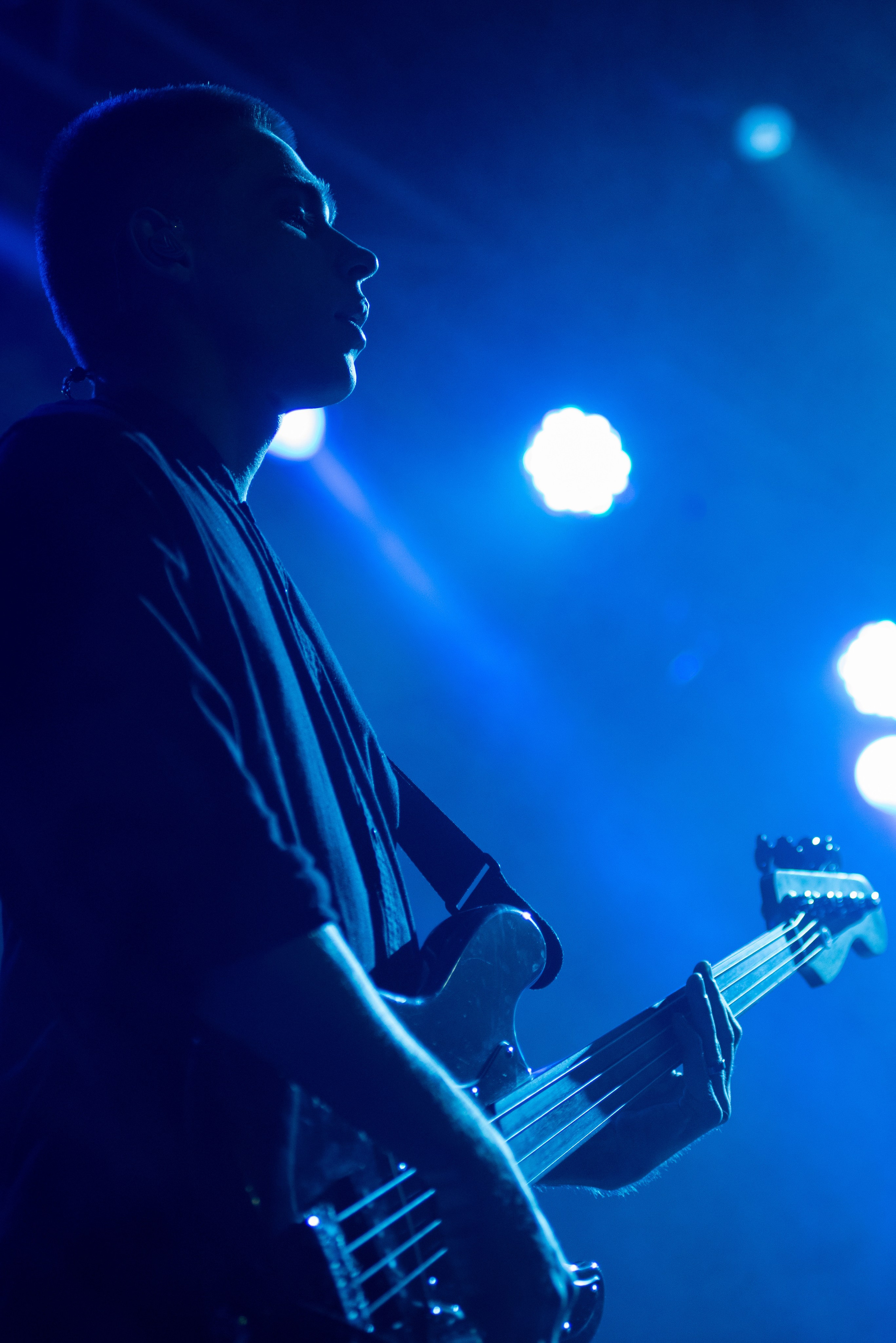 Басист группы «Лампабикт» в синем сценическом свете крупным планом