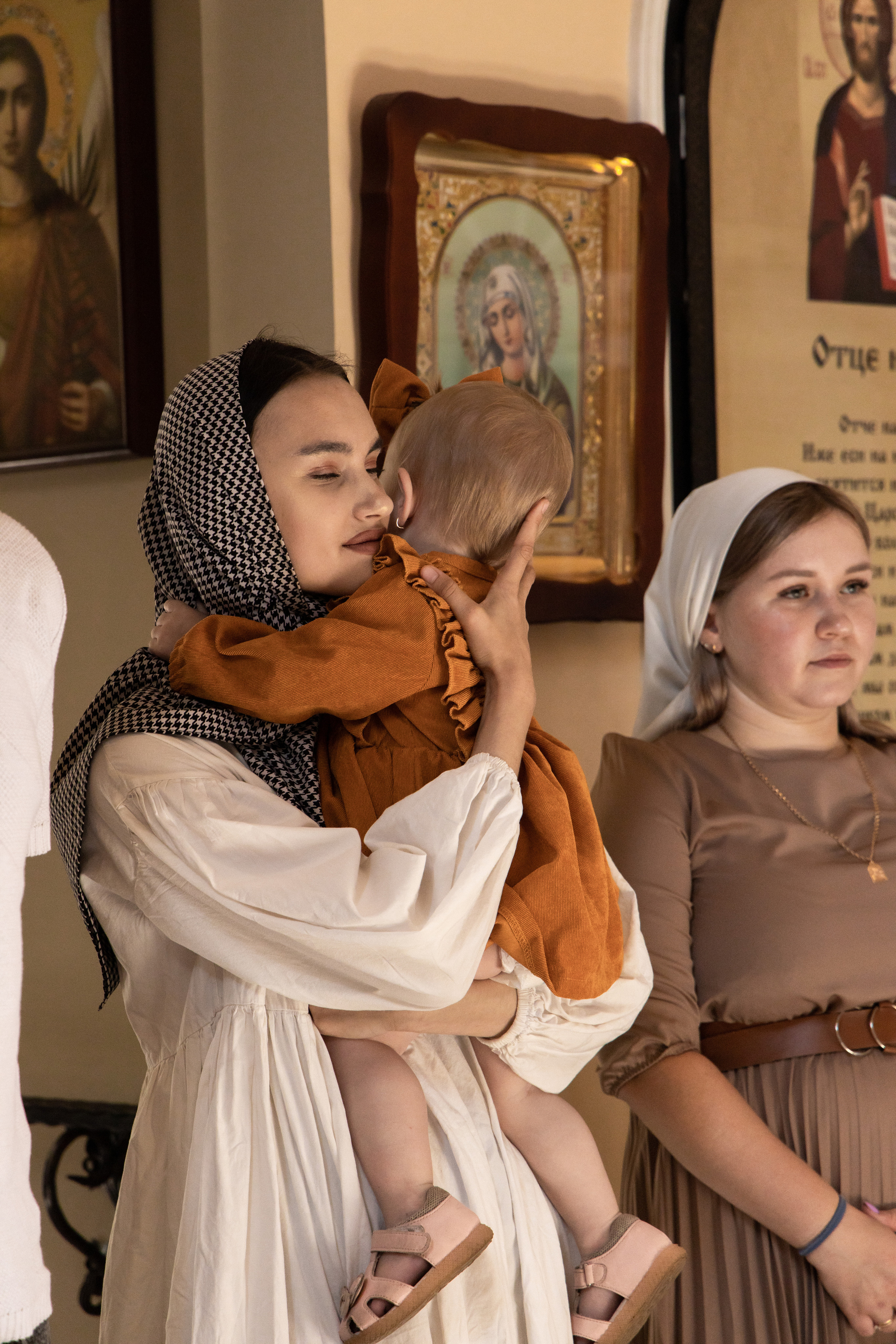 Прихожане с ребёнком на руках в церкви. Крещение фотосессия  Астрахань.