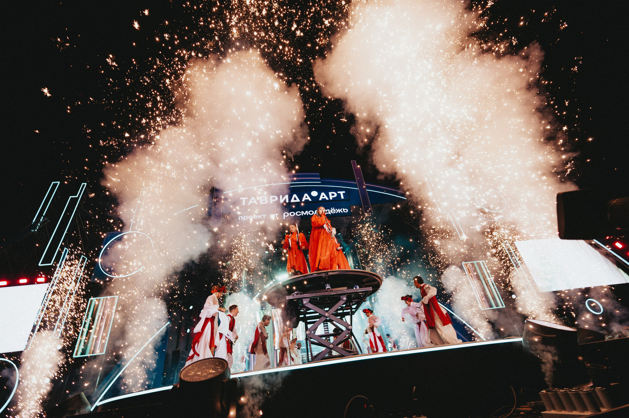 Эффектный кадр сцены со сценическим дымом и певицами во время съемки выступления