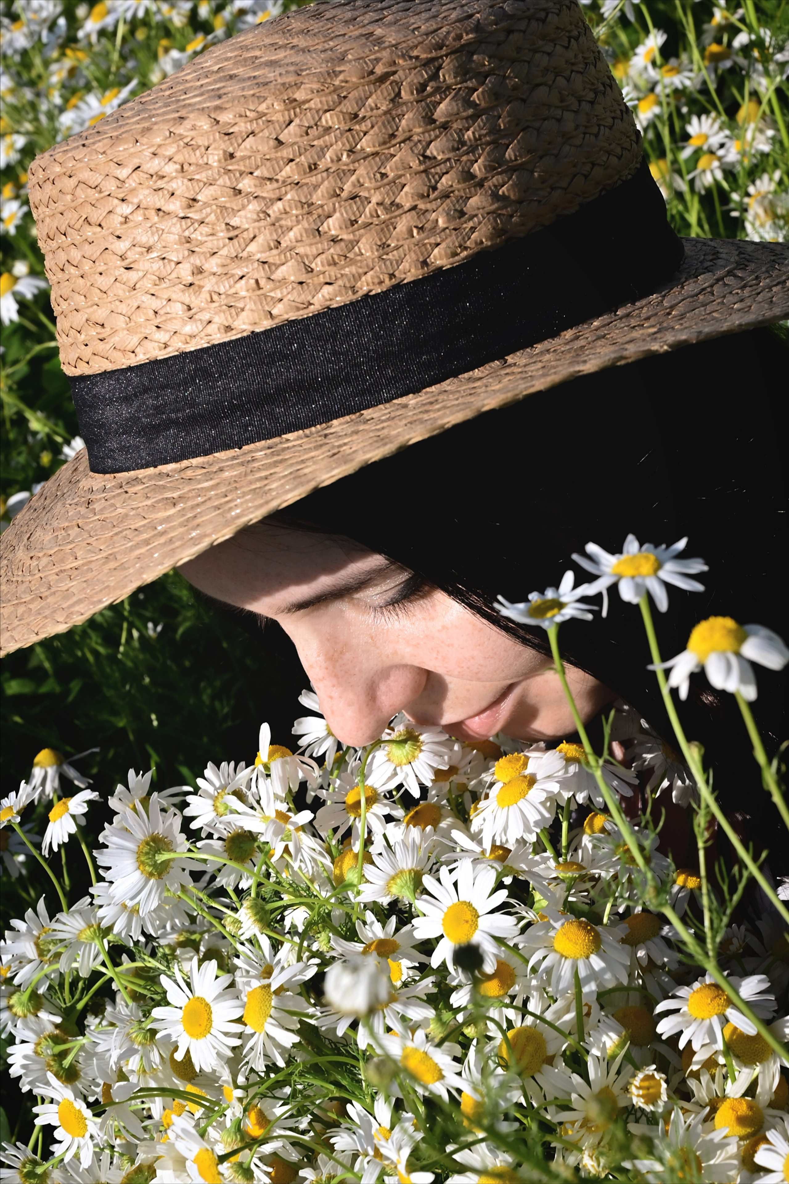 Девушка в шляпе с букетом ромашек