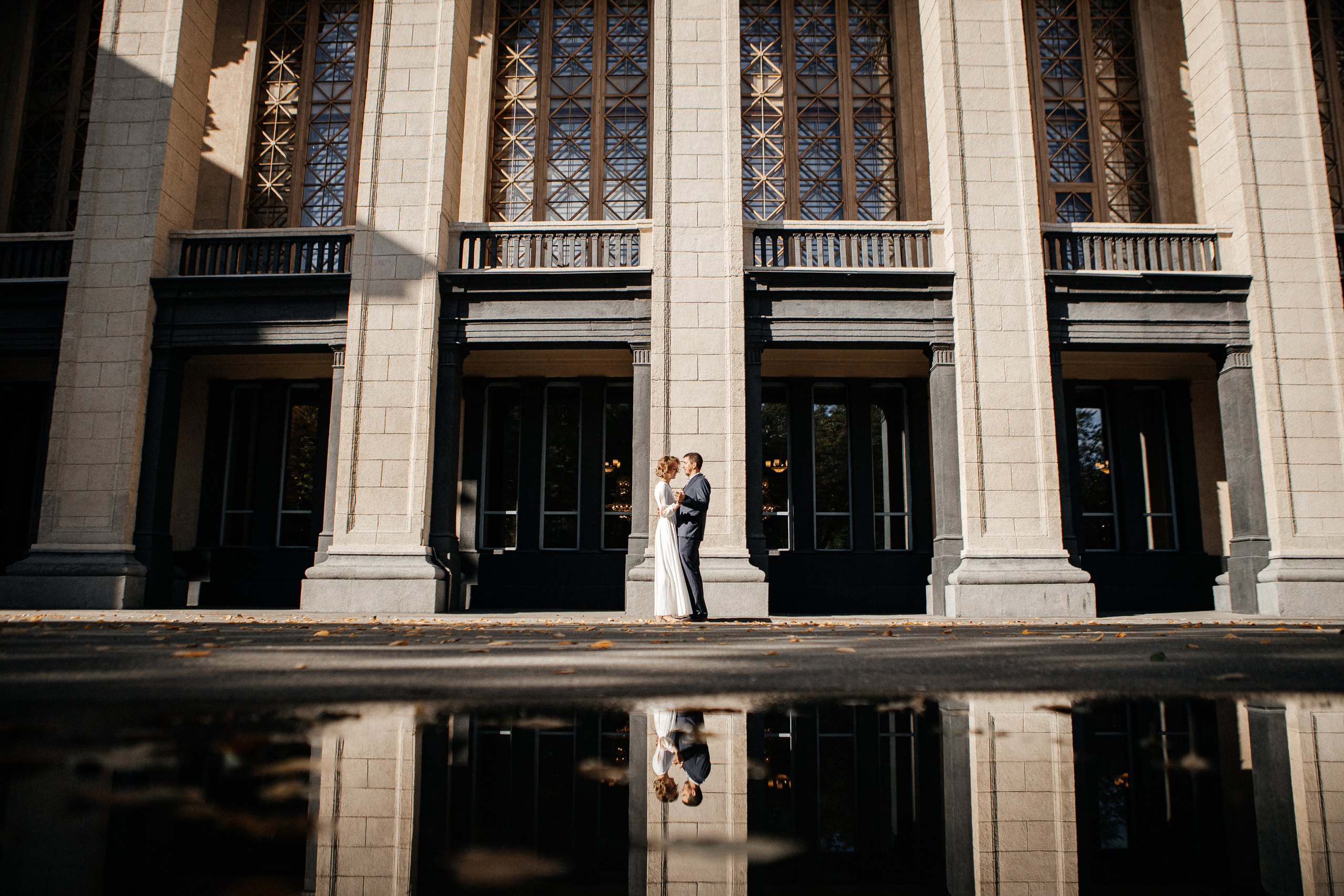 Свадебная фотосессия жениха и невесты на фоне колонн оперного театра