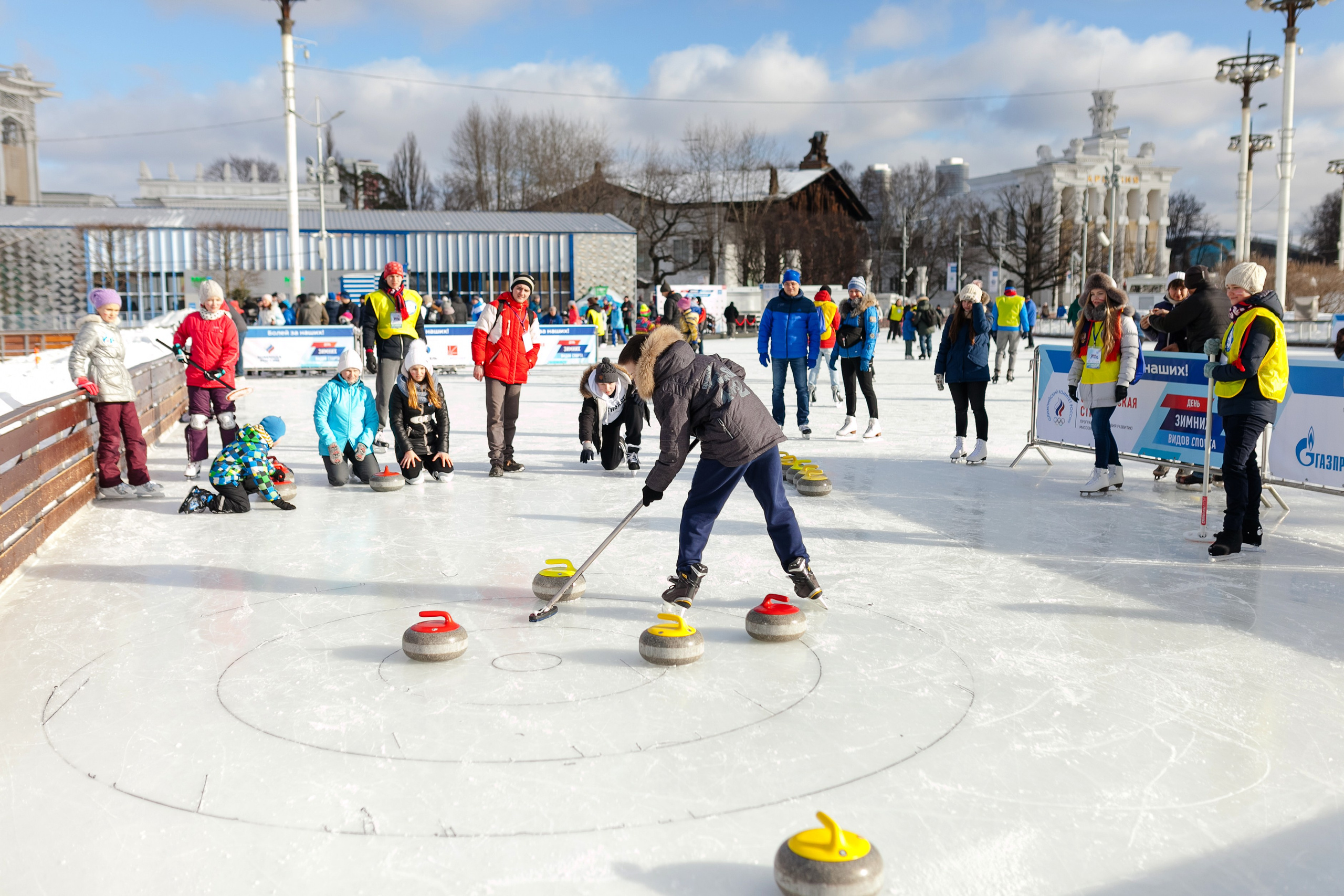 Жители Москвы играют в керлинг на катке ВДНХ на фестивале зимних видов спорта