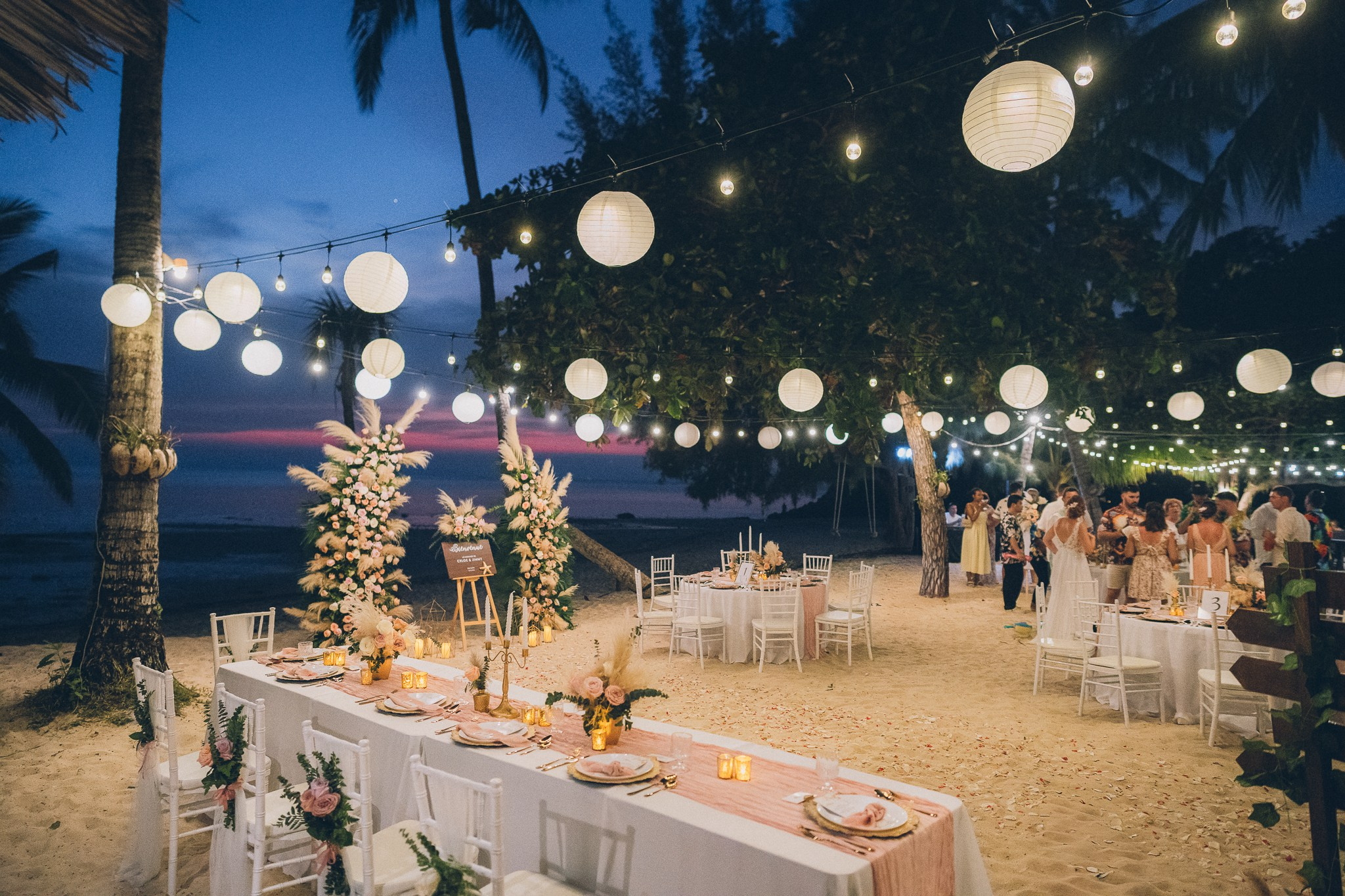 Wedding celebration with guests on a tropical sunset beach in Koh Samui