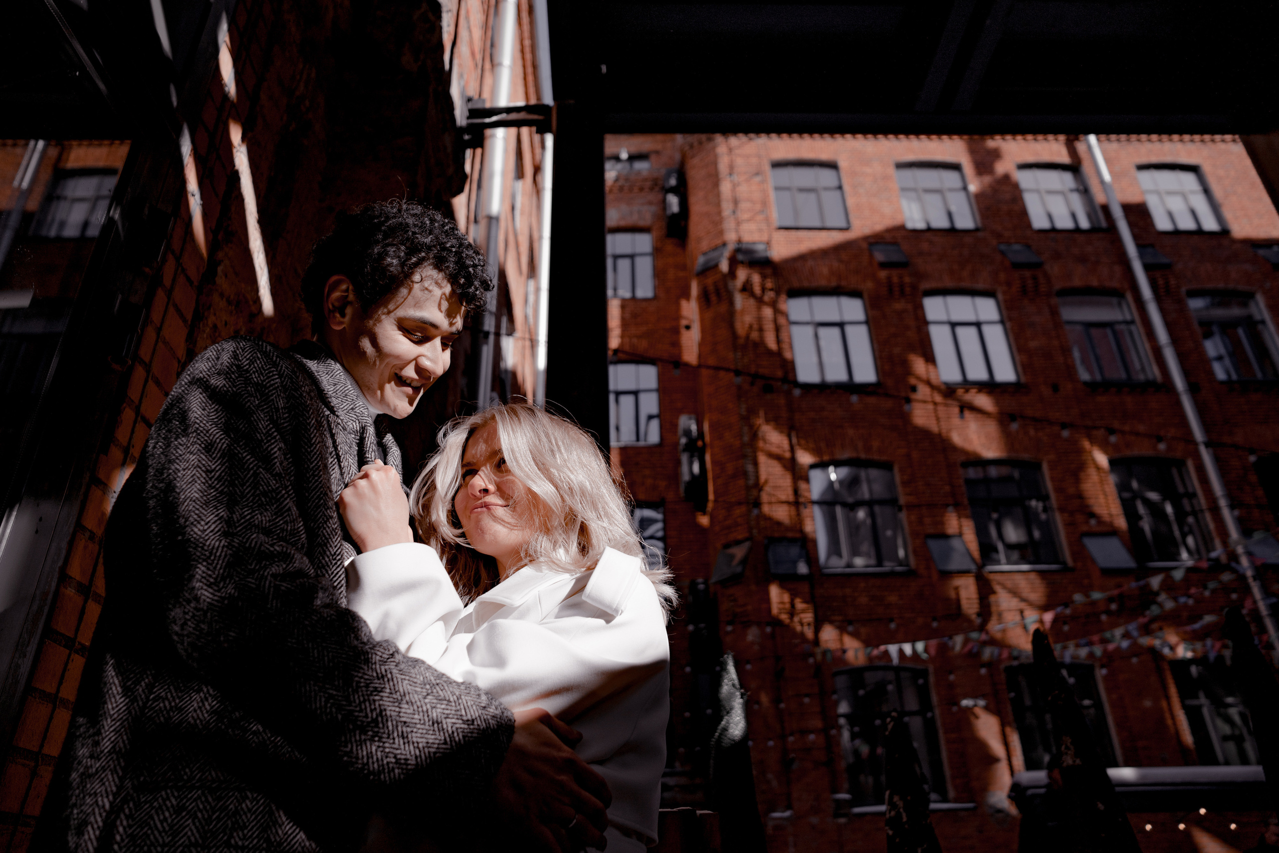 Красивая пара обнимается в лучах солнца в Бергольдц центре в Санкт-Петербурге.