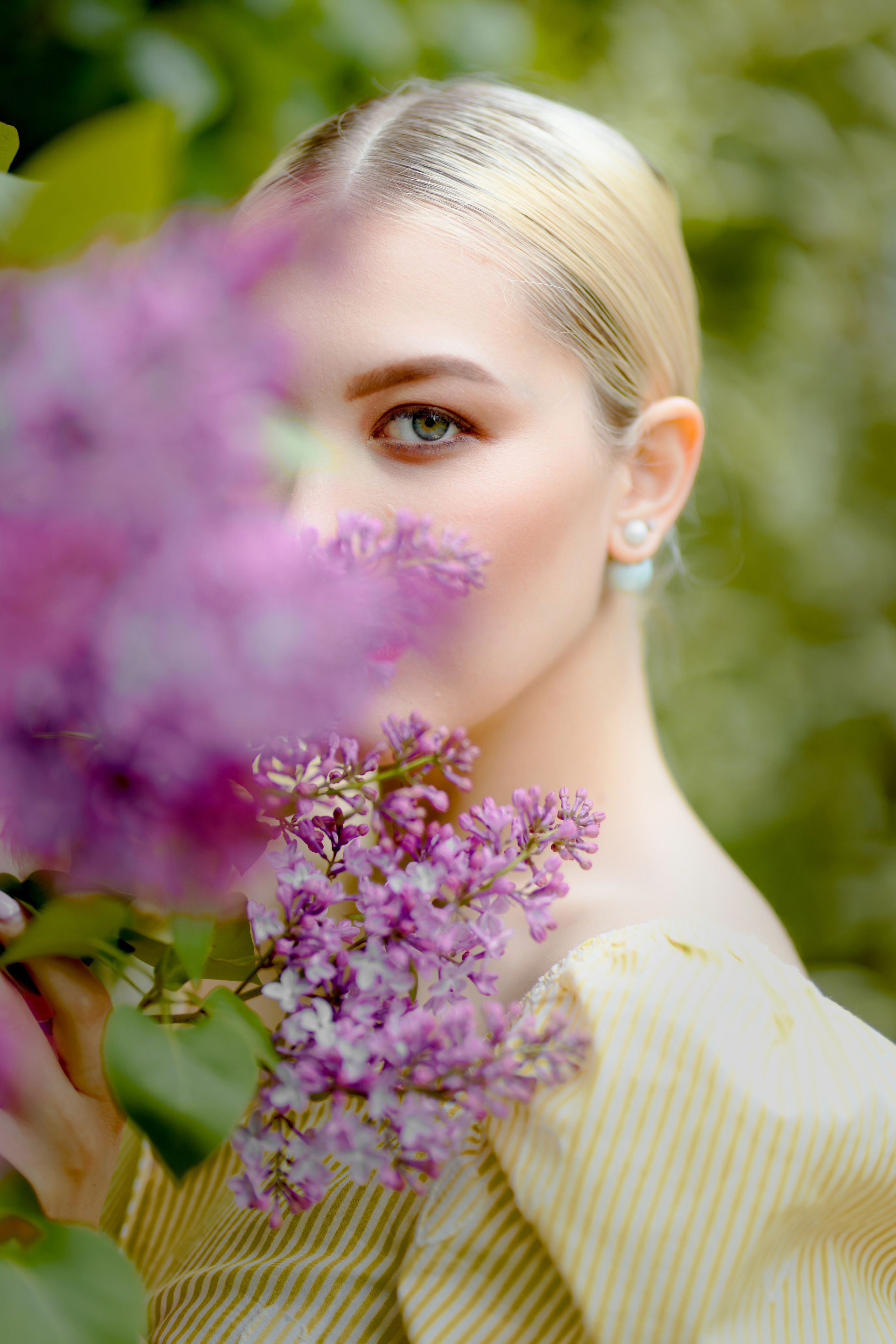 Весенний портрет девушки с веткой сирени, крупный план, размытый зеленый фон, нежный образ, естественное освещение