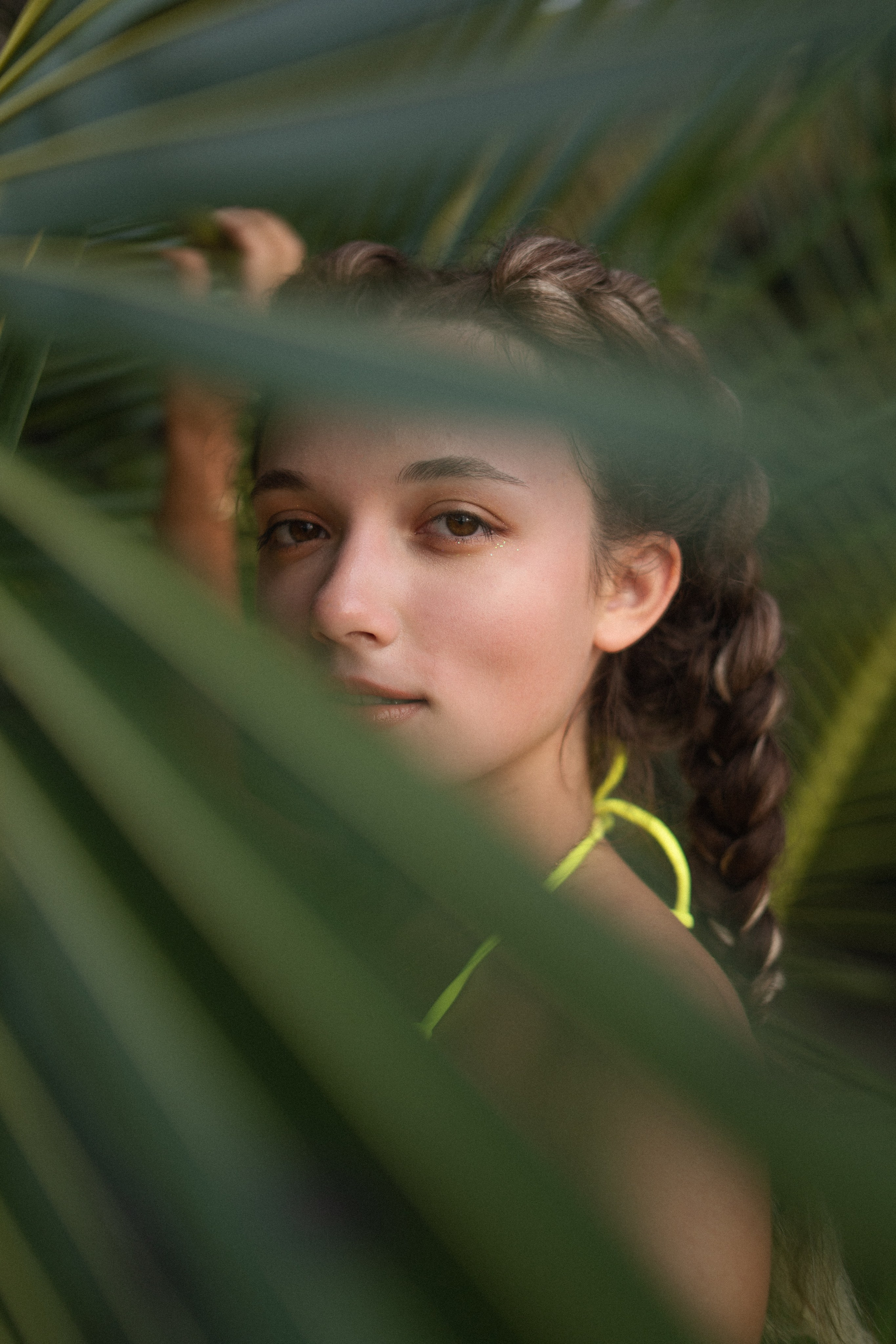 a girl with braids in a yellow swimsuit with ocean waves in the background