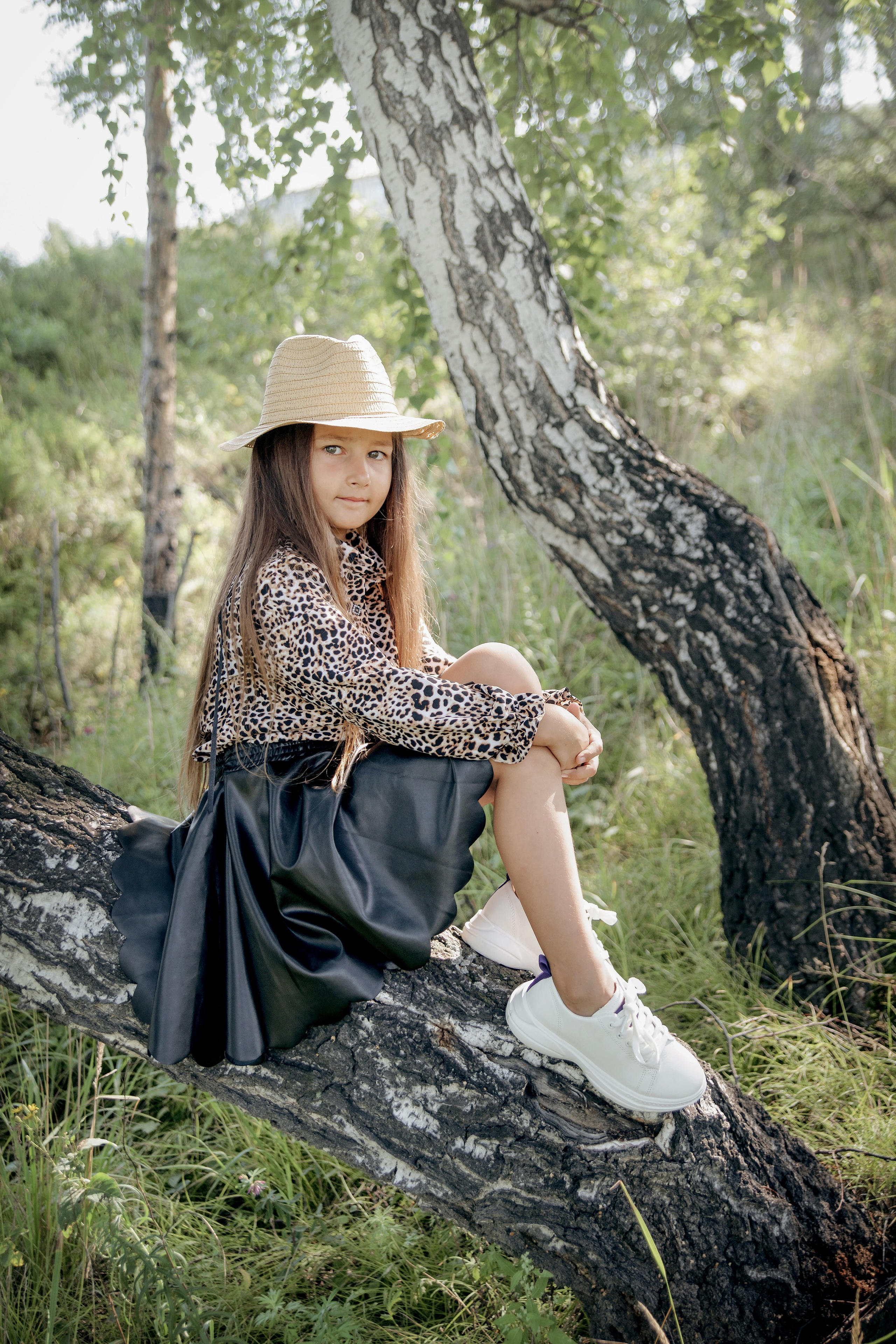 Детская фотосессия летом - девочка сидя на дереве
