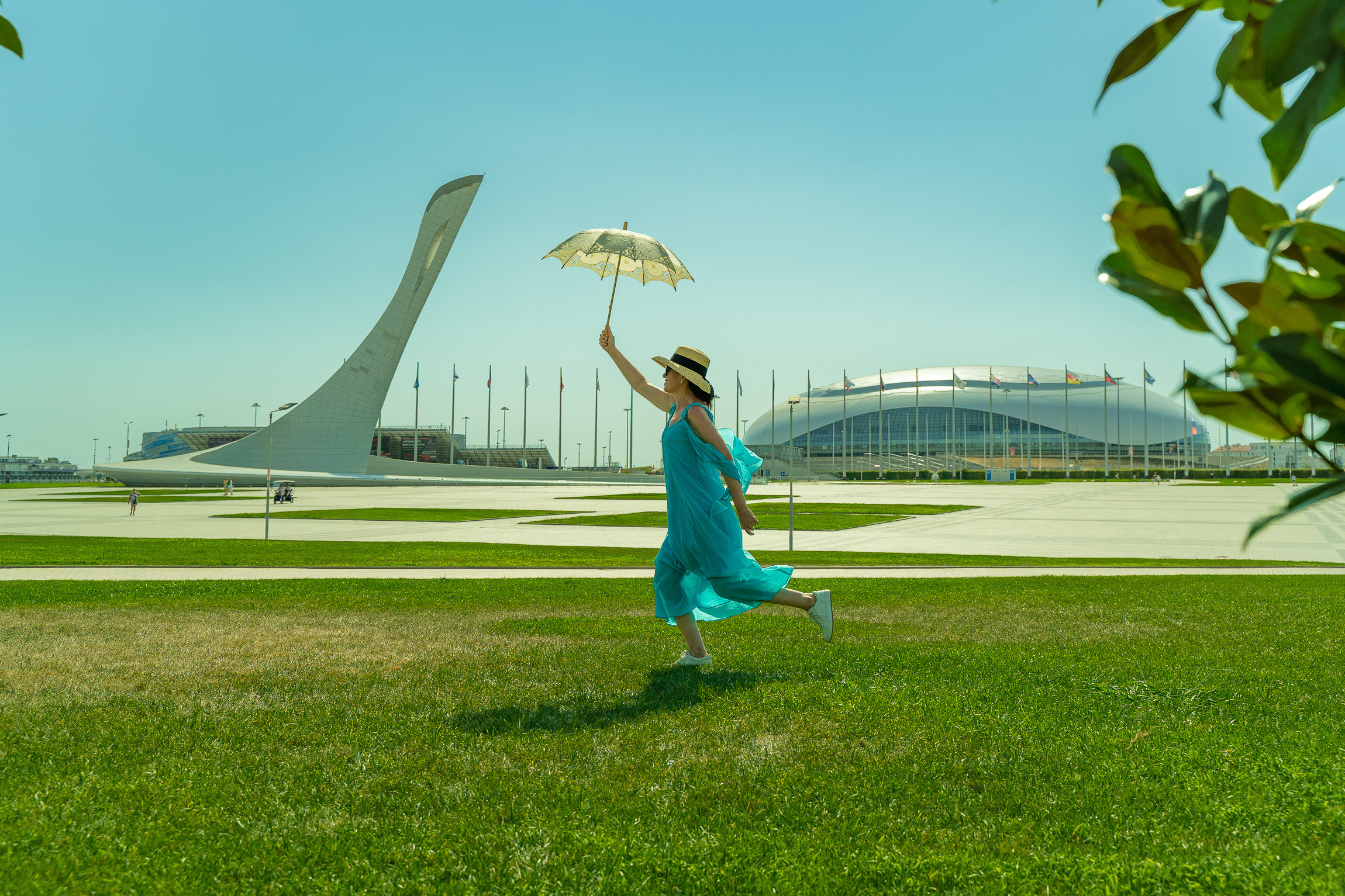 Фотосессии в Сириусе Олимпийский парк бегущая девушка в голубом платье с зонтиком