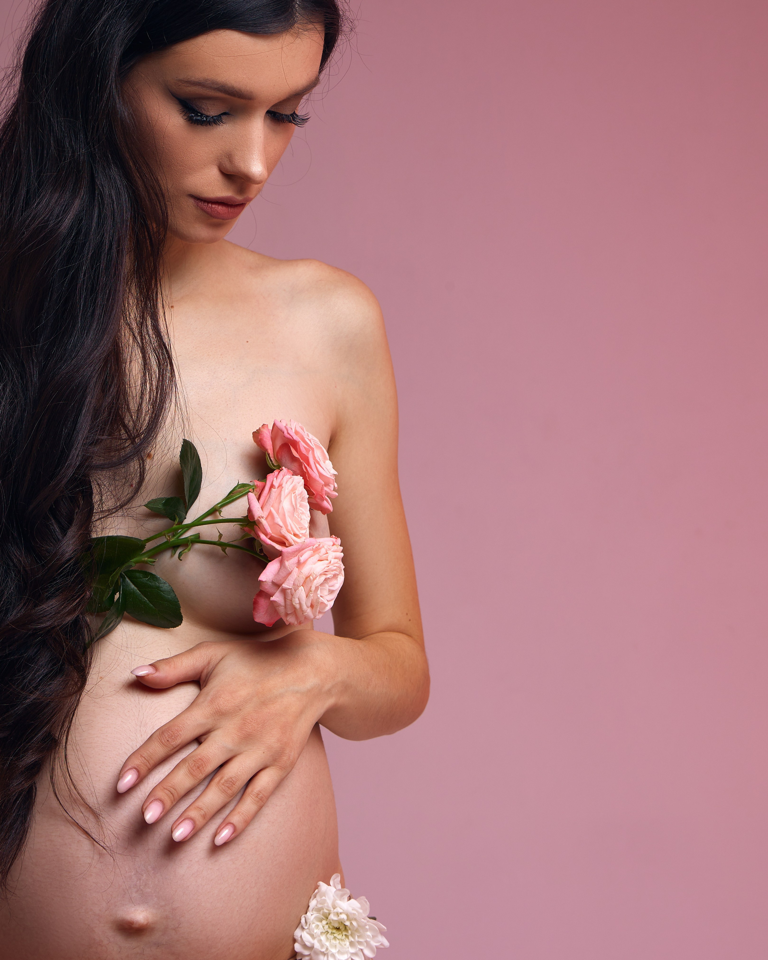 Беременная девушка в фотостудии в цветах