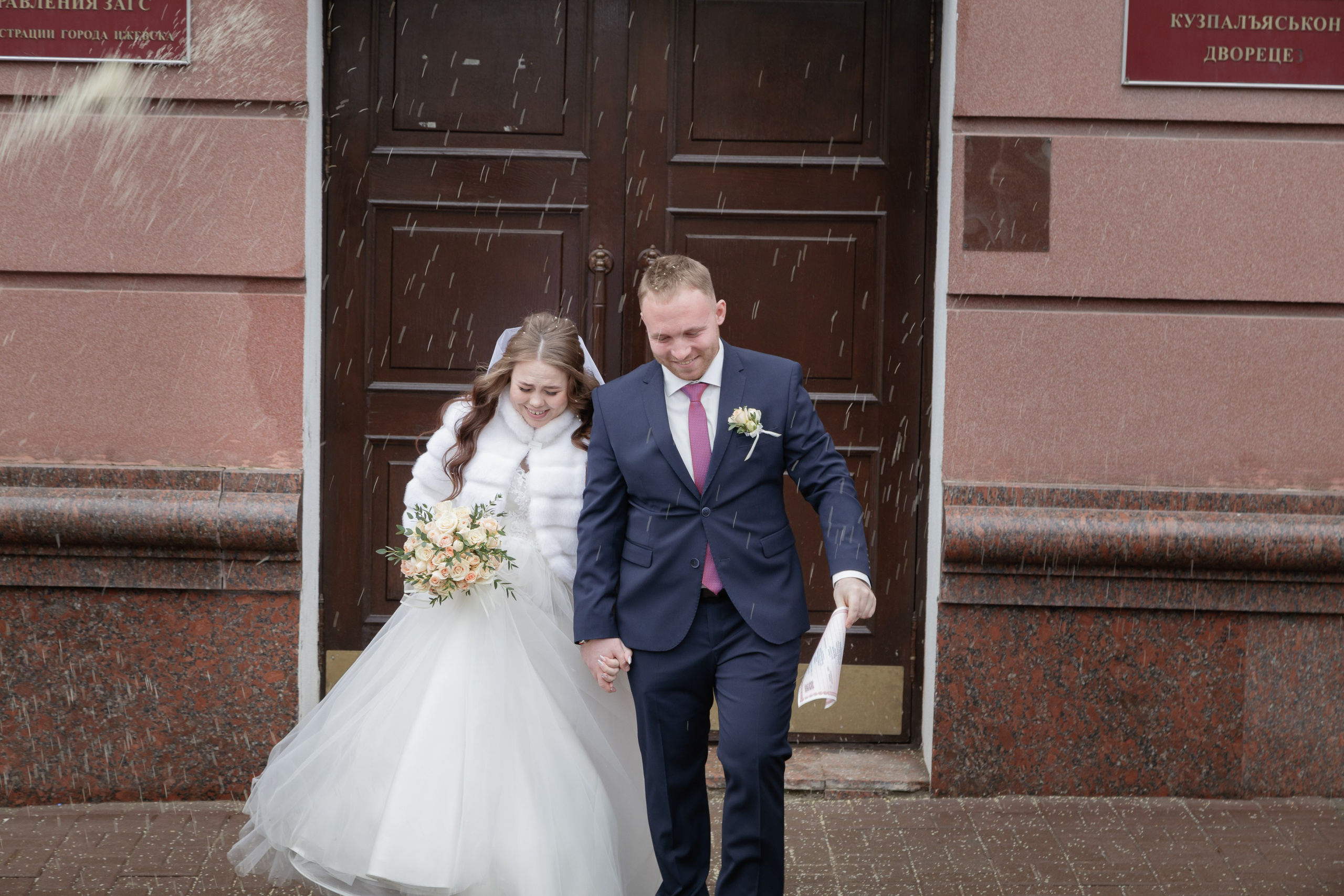 Гости кидают в молодоженов рисом возле дверей ЗАГСа