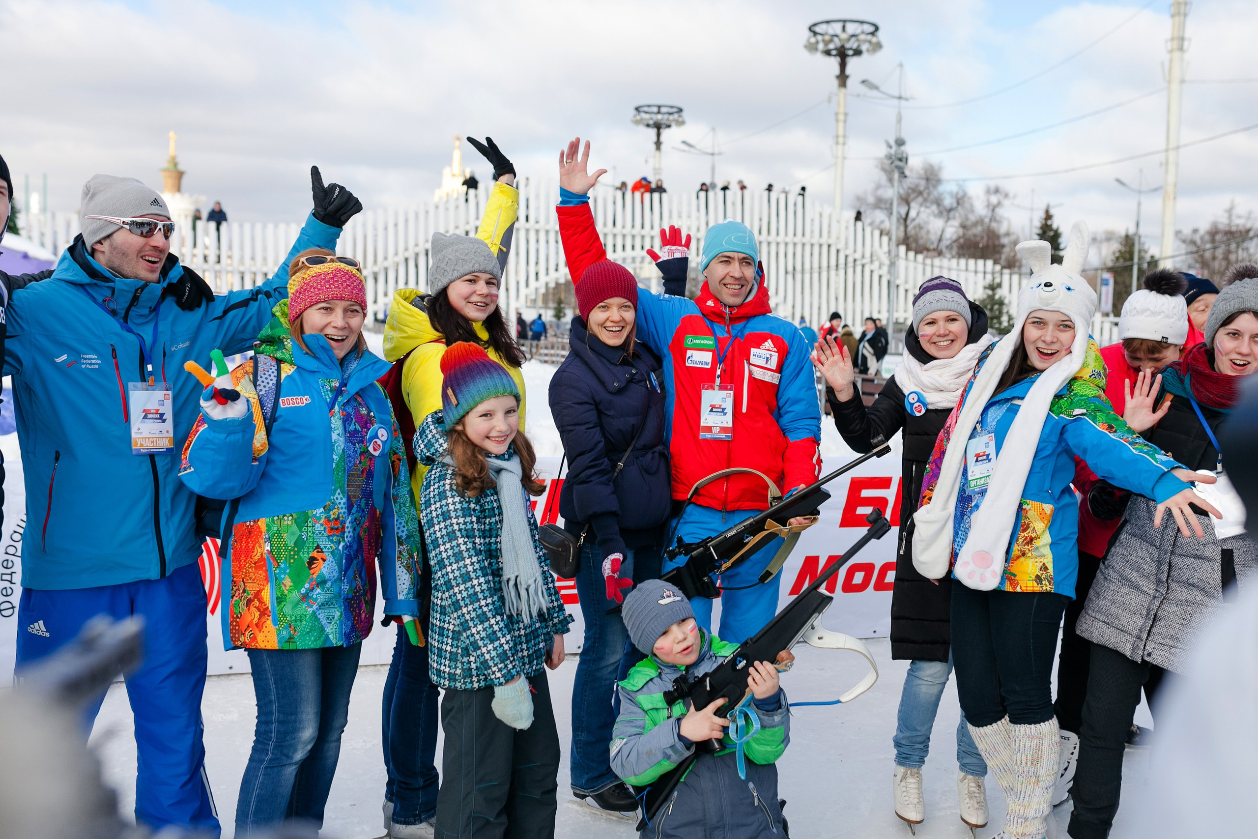 Весёлая толпа людей разноцветных одеждах фотографируются на фестивале зимних видов спорта на ВДНХ
