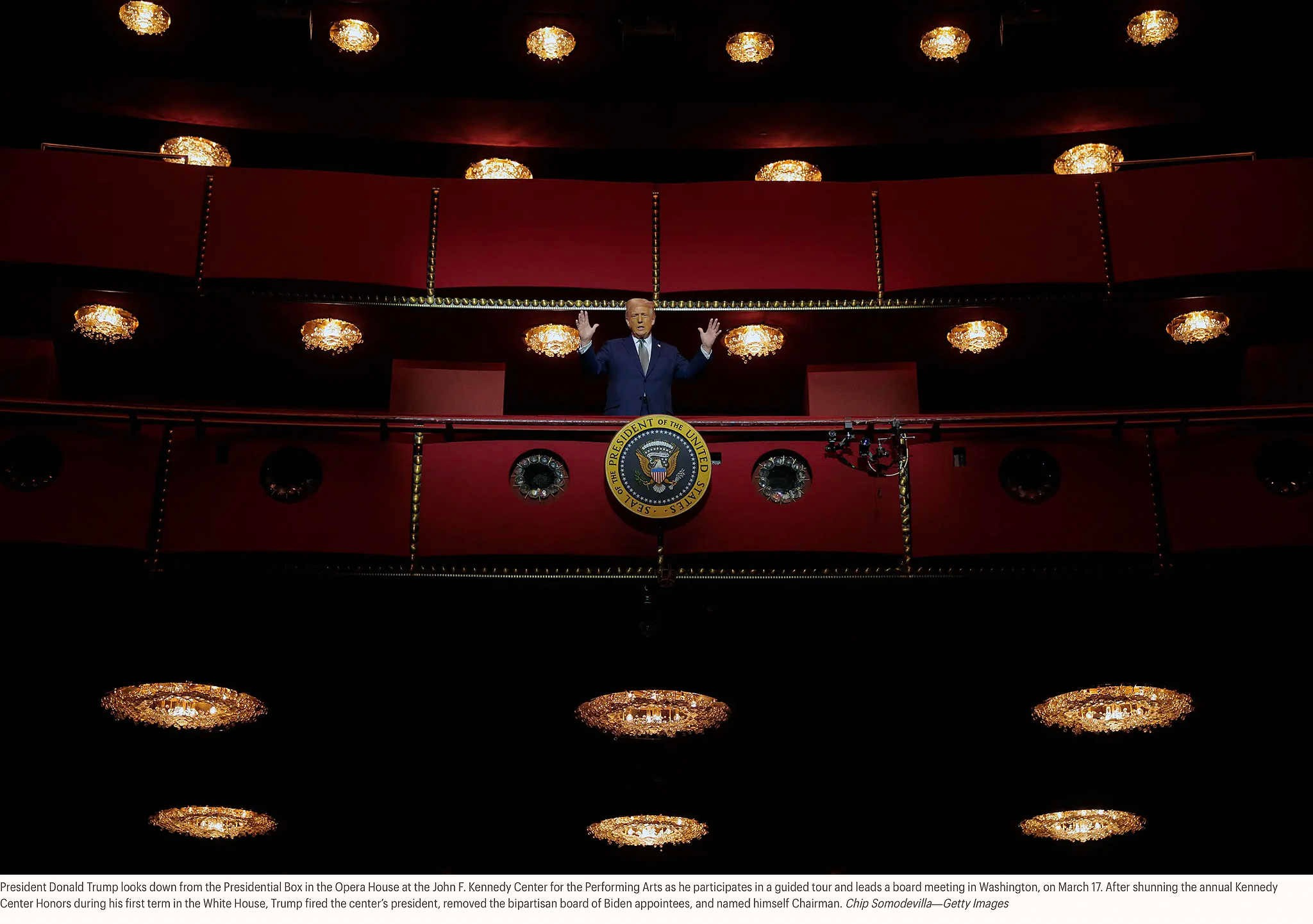 Президент Дональд Трамп смотрит вниз из президентской ложи в Оперном театре Центра исполнительских искусств имени Джона Ф. Кеннеди, участвуя в экскурсии и проводя заседание совета директоров в Вашингтоне, 17 марта. После того как Трамп проигнорировал ежегодную церемонию вручения наград Центра Кеннеди во время своего первого срока в Белом доме, он уволил президента центра, отстранил от должности двухпартийный совет директоров, назначенный Байденом, и провозгласил себя председателем. Чип Сомодилья — Getty Images