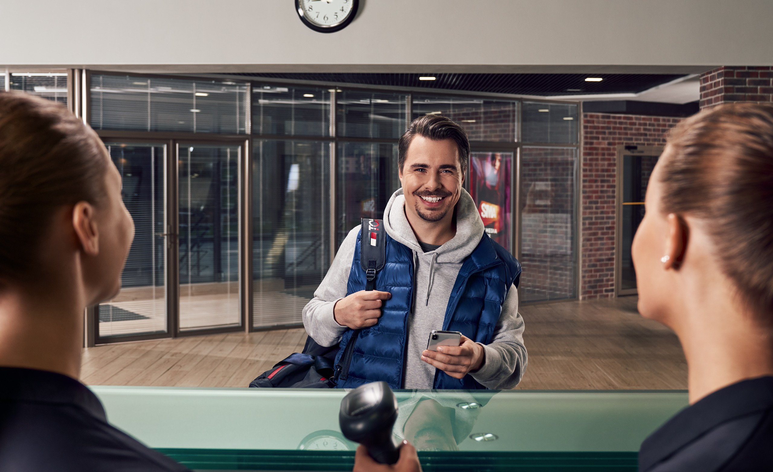 Гостя спортивного клуба встречают две девушки на входе