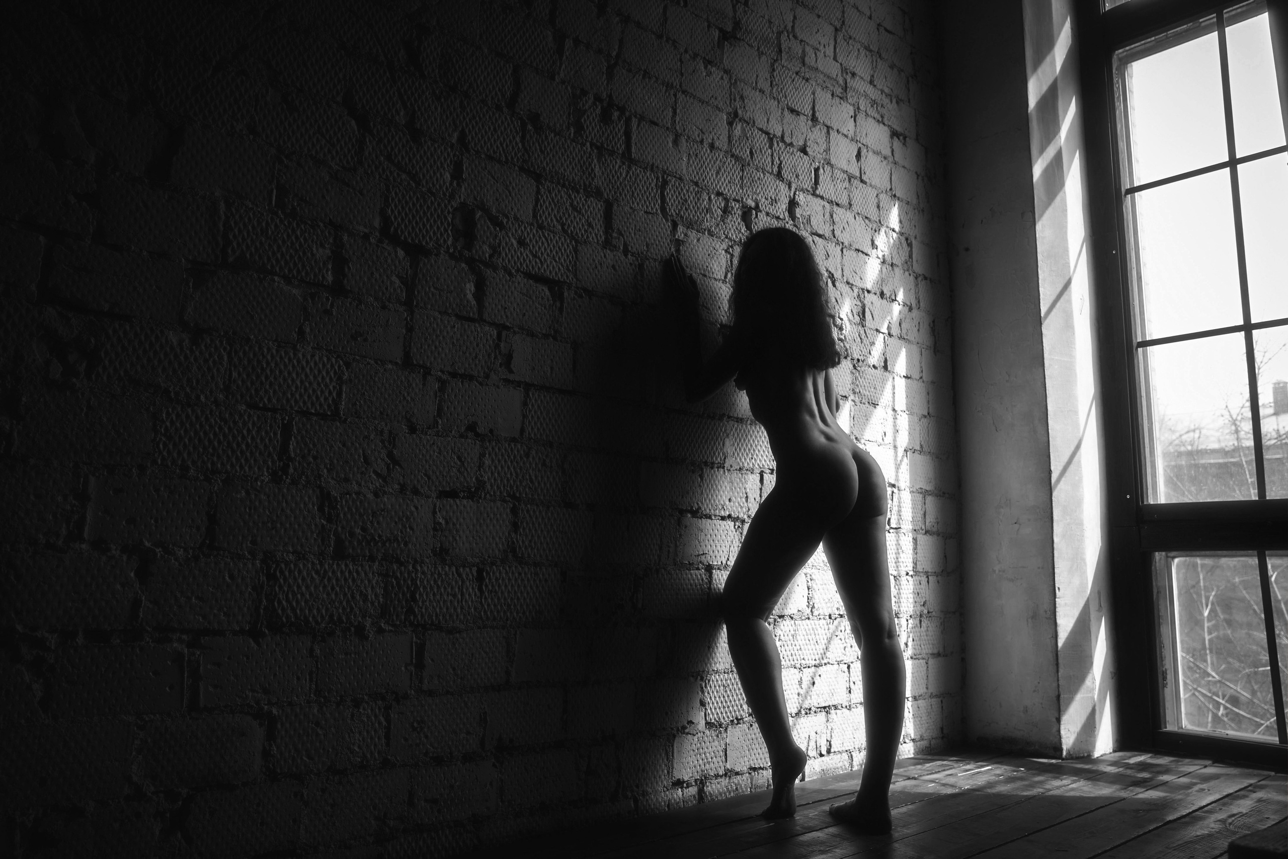 девушка в полный рост позирует фотографу ню во время эротической фотосессии в студии