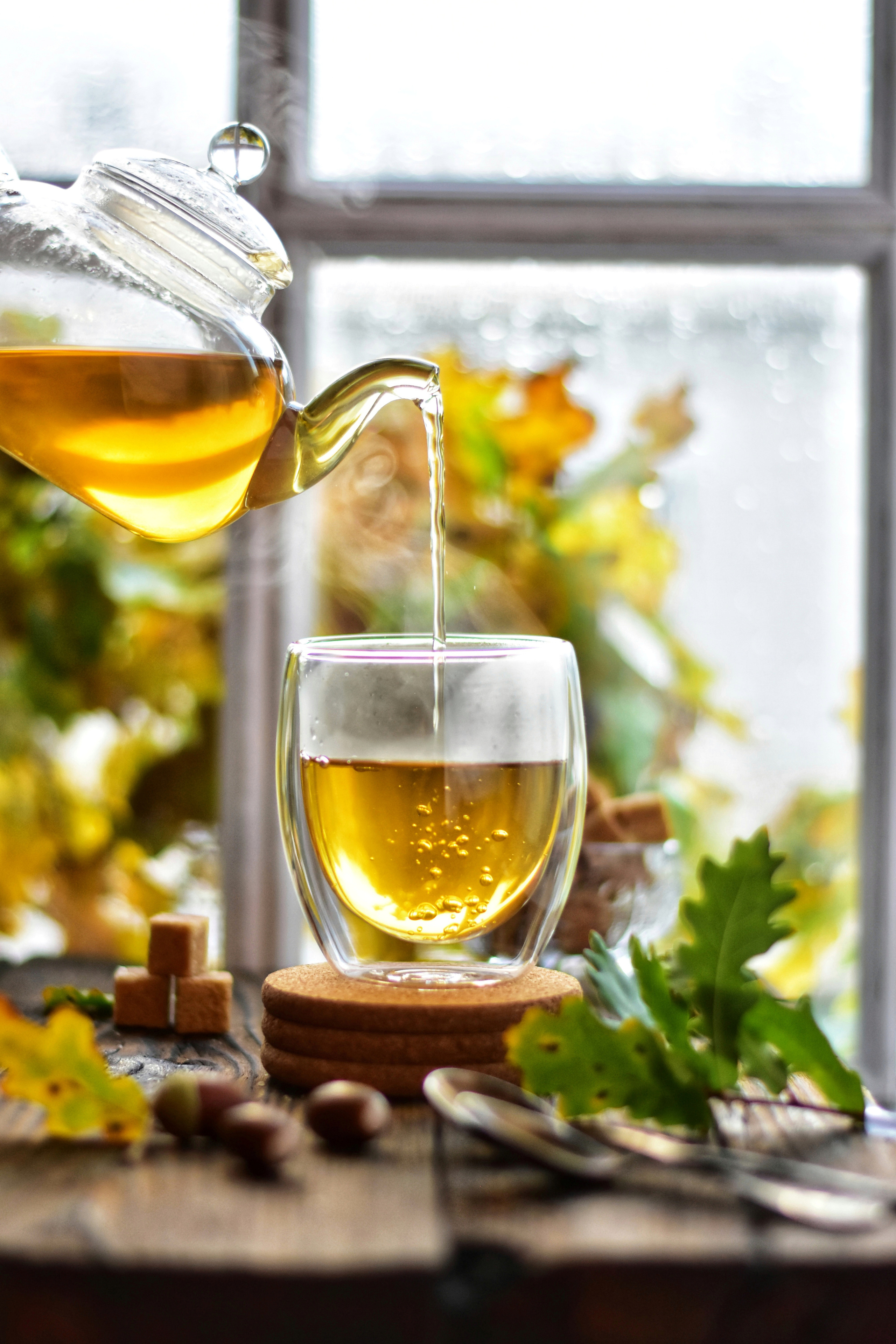 человек наливает чай в стеклянную чашку