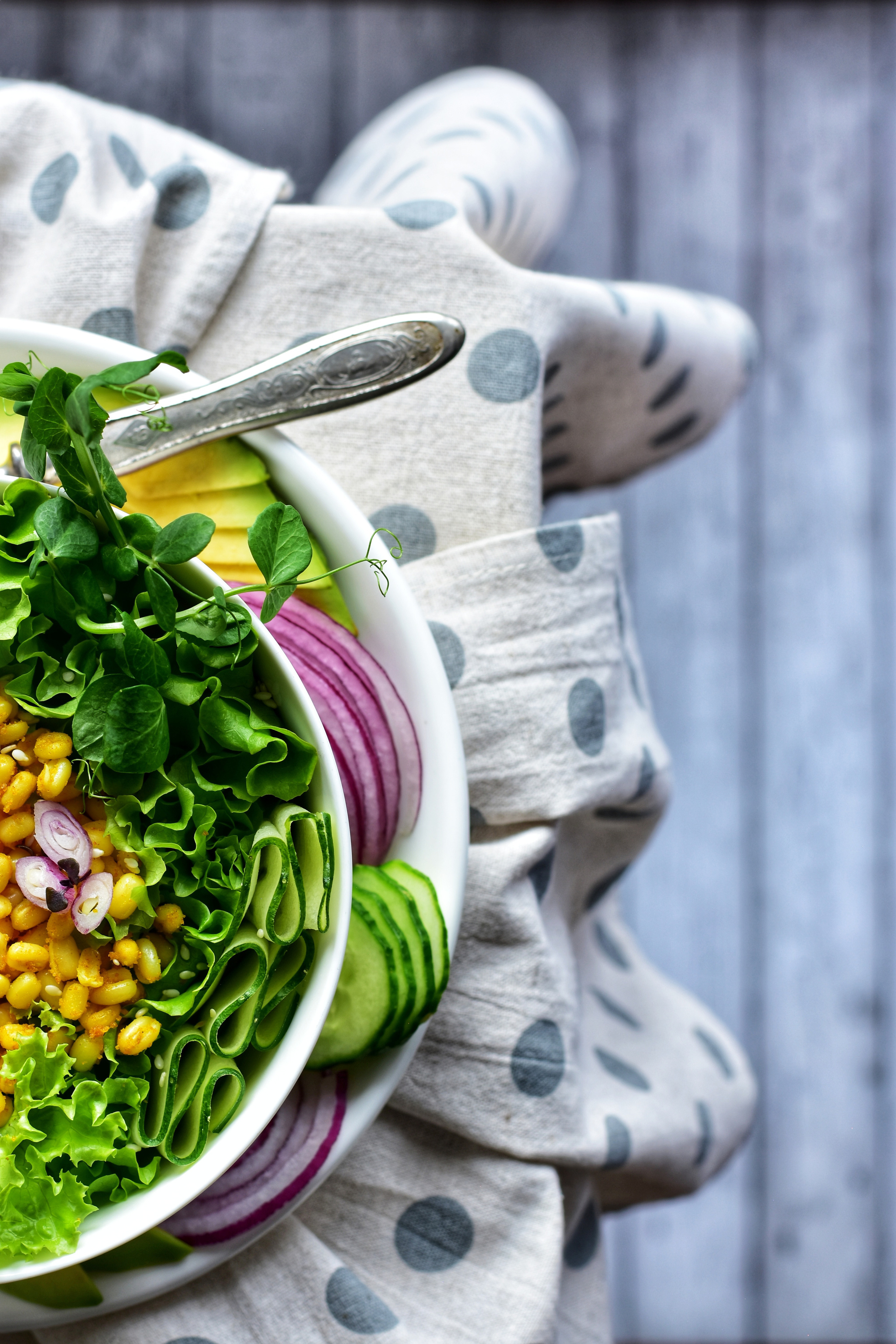 Фото композиция белая миска, наполненная кукурузой и овощами.