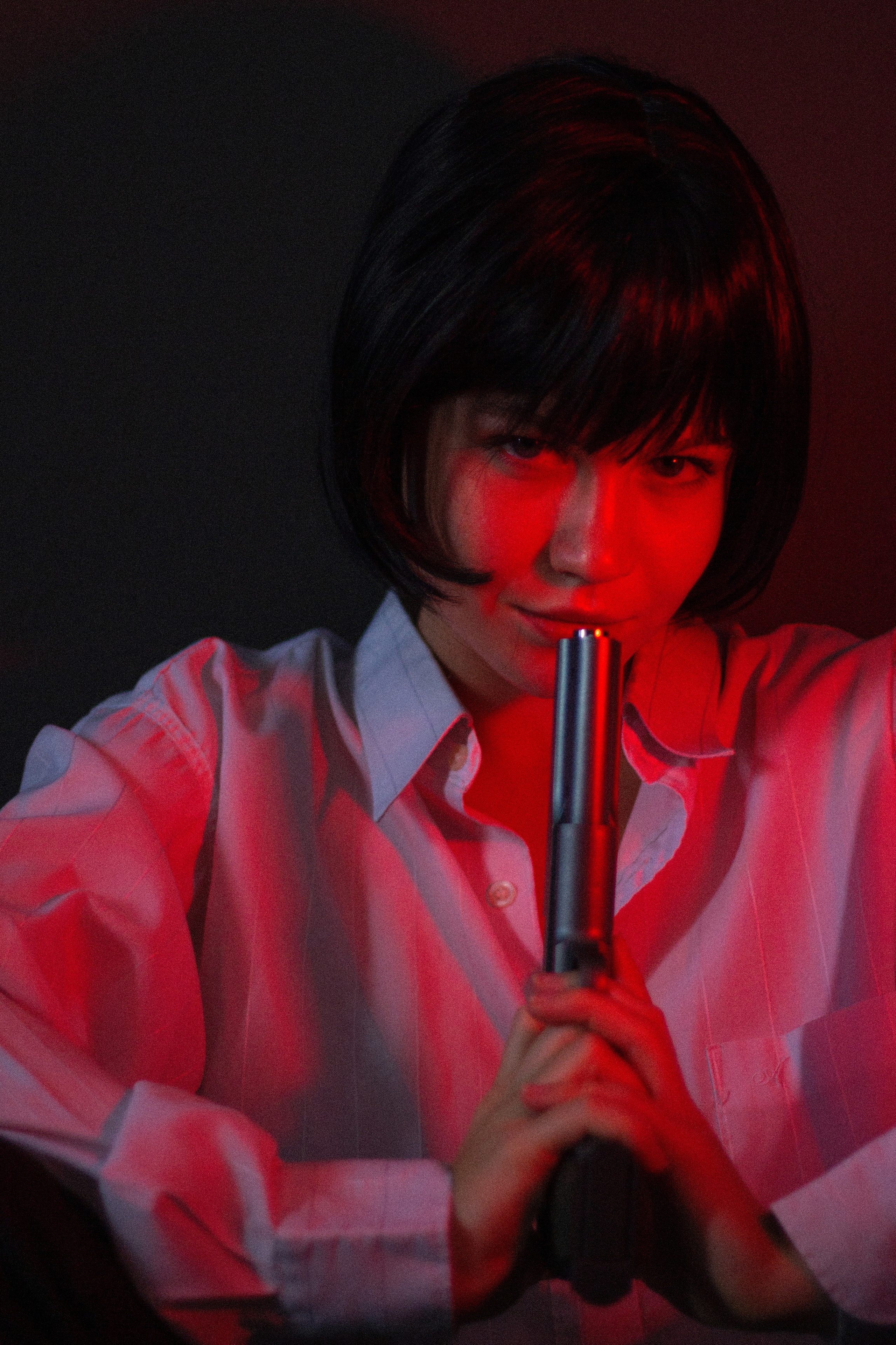 Девушка в белой рубашке в студии с пистолетом. Тёмный красный свет. FromIvanov фотограф Санкт-Петербург