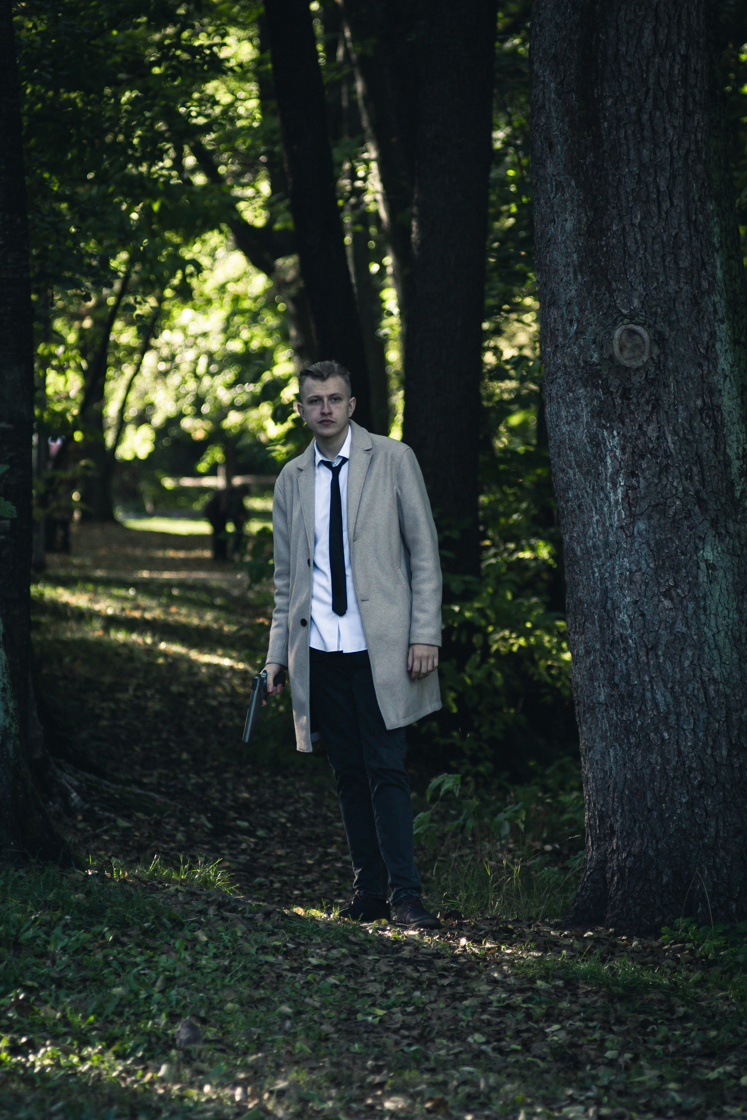 Детектив на улице с пистолетом среди деревьев. Фотосессия. FromIvanov фотограф в Санкт-Петербурге