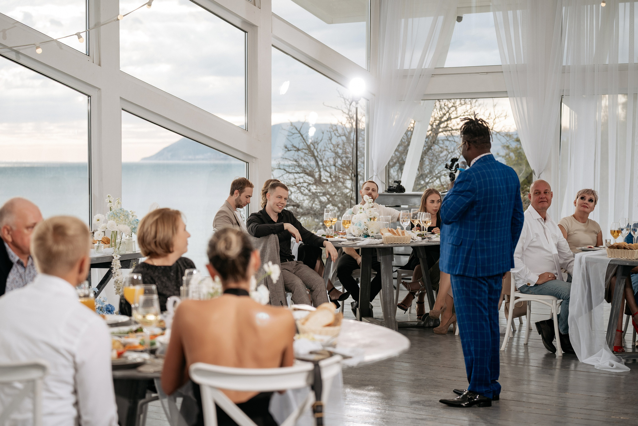 Фотограф Геленджик запечатлел тост гостей на свадебном банкете с видом на море.