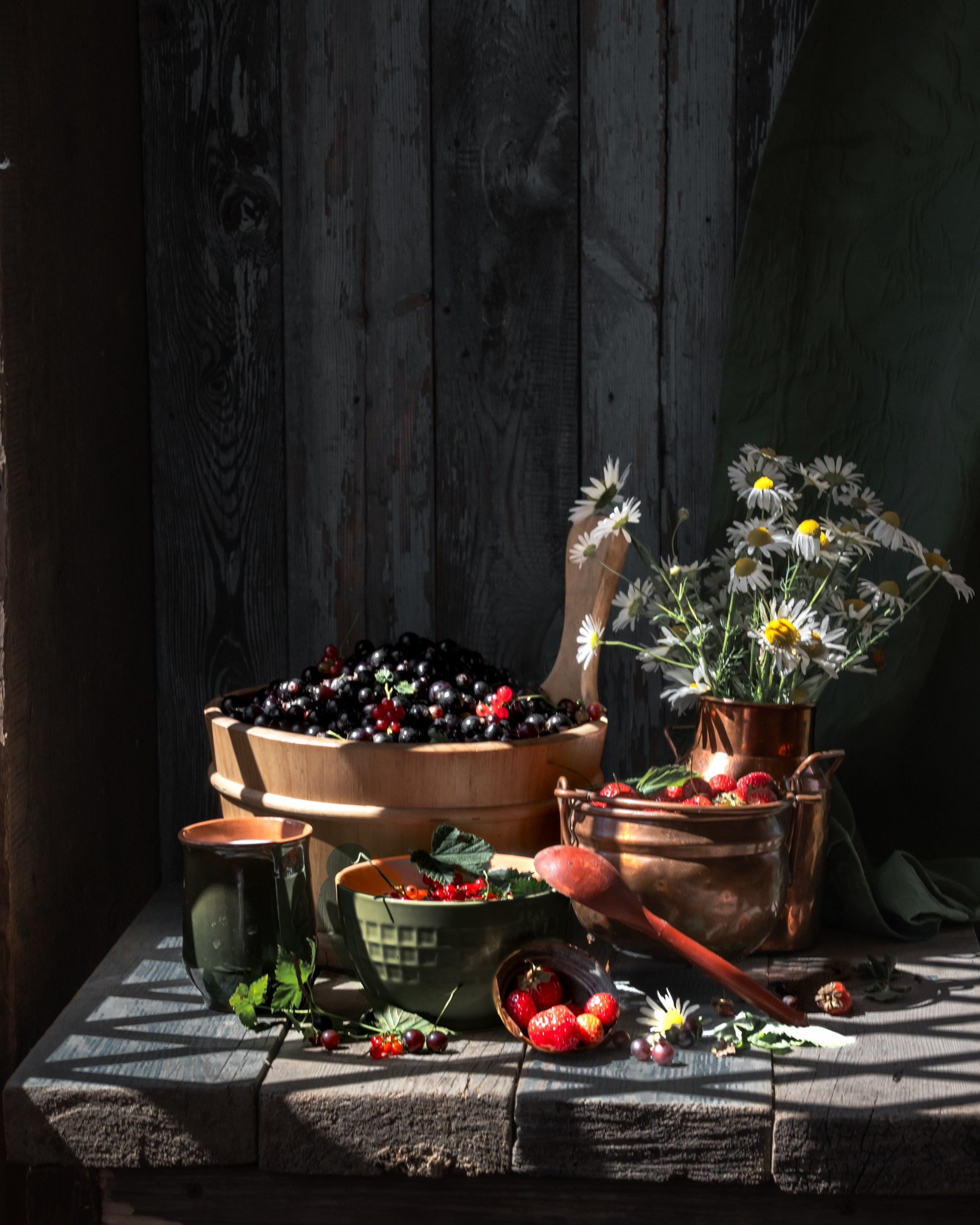 Чёрная смородина на деревенском столе, создающая атмосферу летнего урожая.