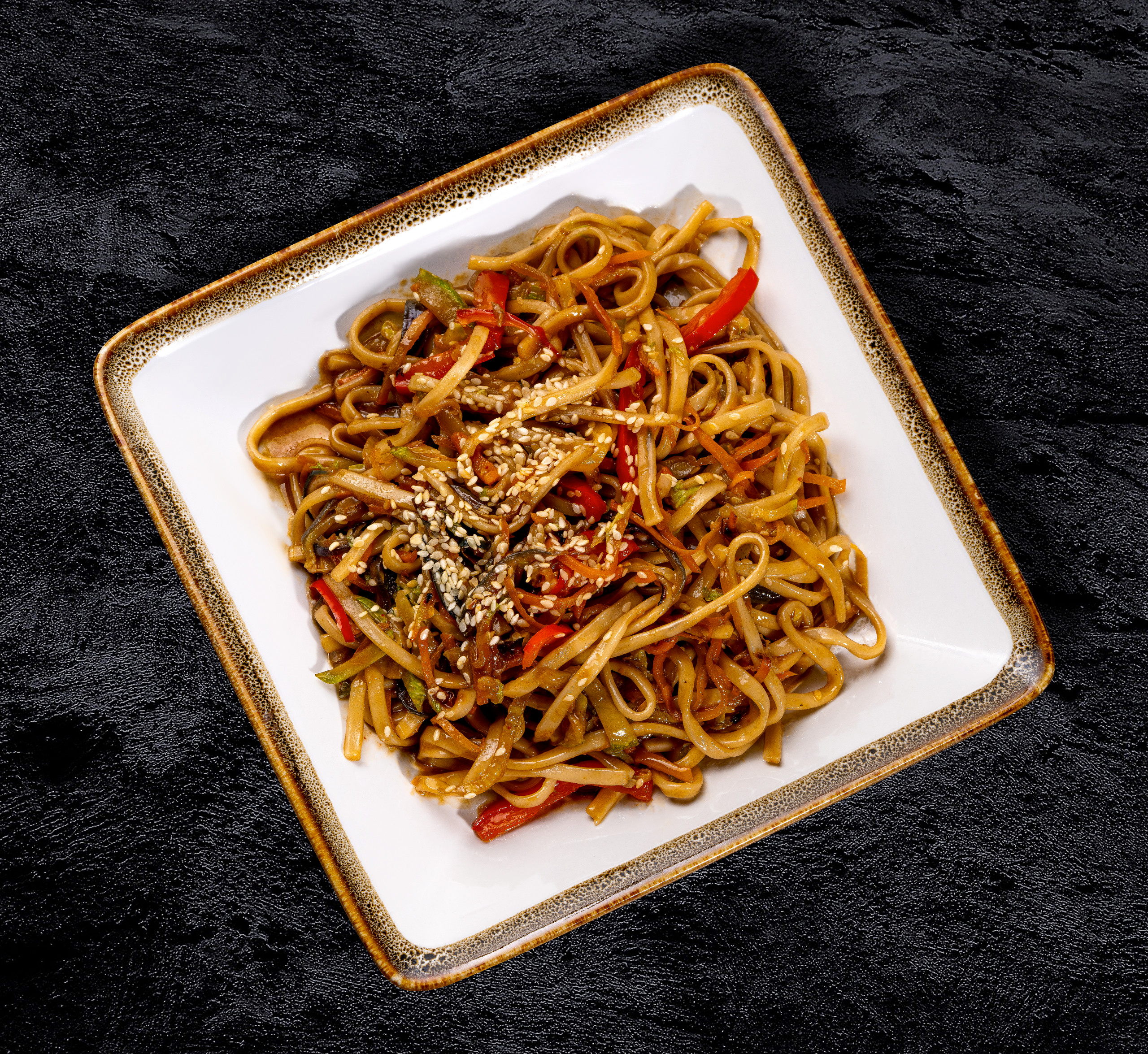 Удон на квадратной тарелке с соусом сфотографированный фуд фотографом