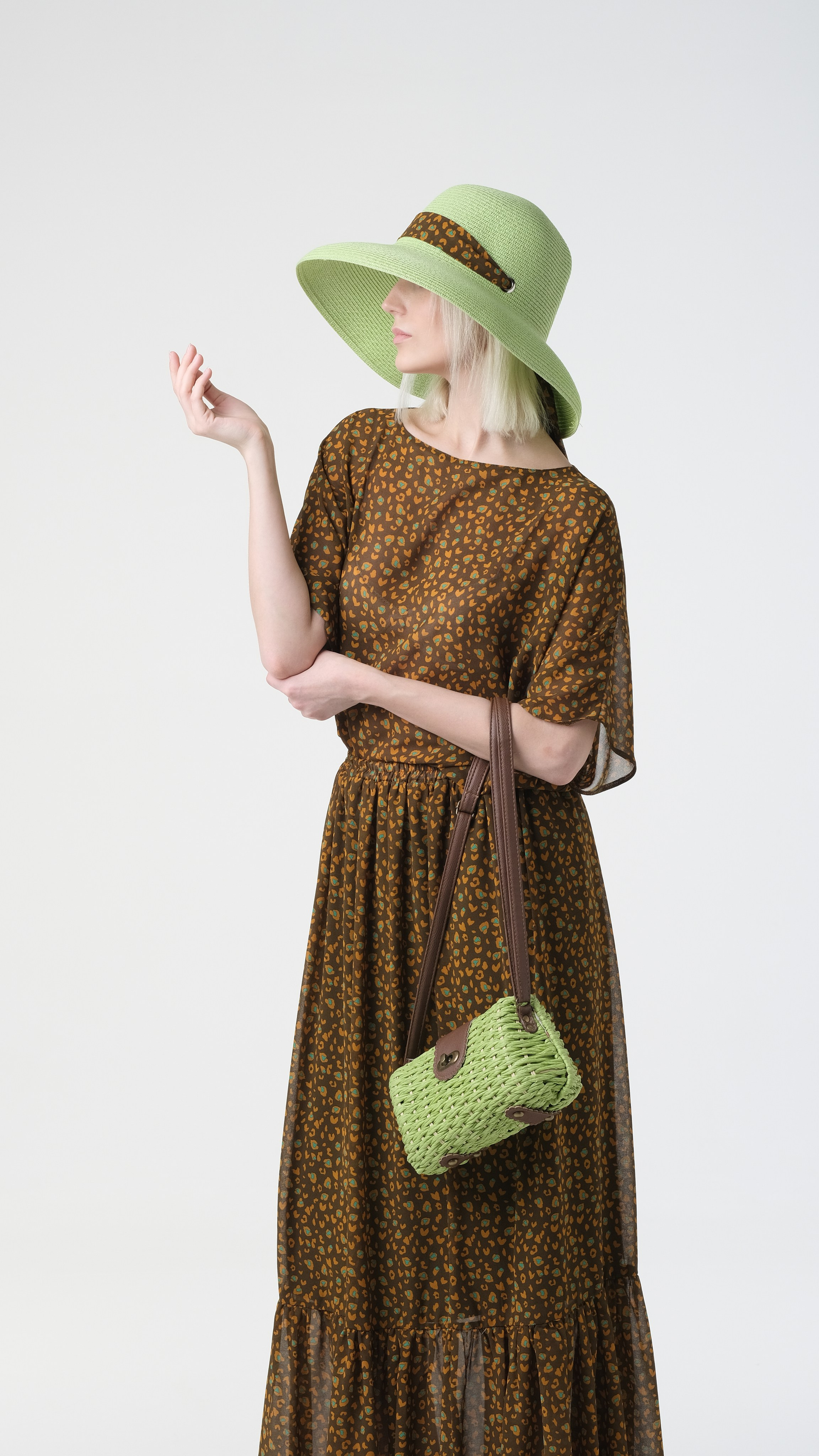 Красивое позирование модели в зелёной шляпе и с зеленой сумочкой. Подбор моделей в Москве. Фотосъёмка на циклораме.