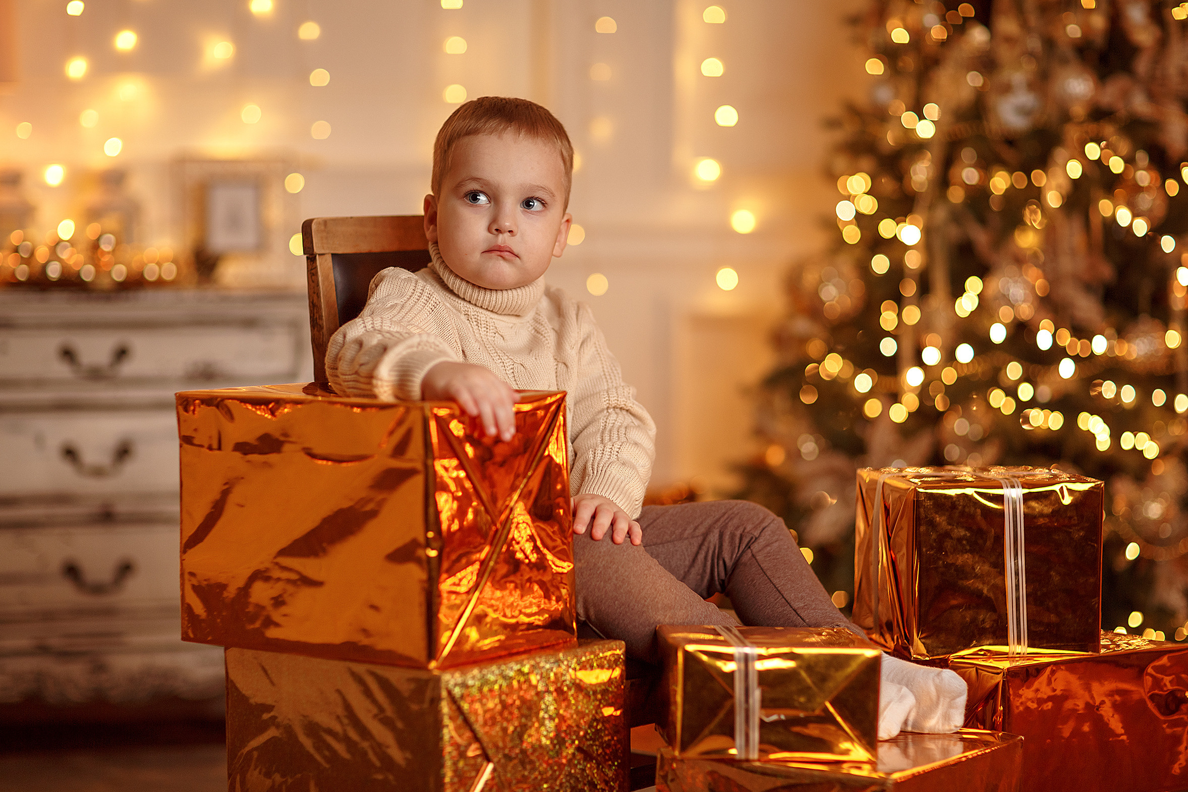 детская новогодняя фотография ребенка в коробках с подарками