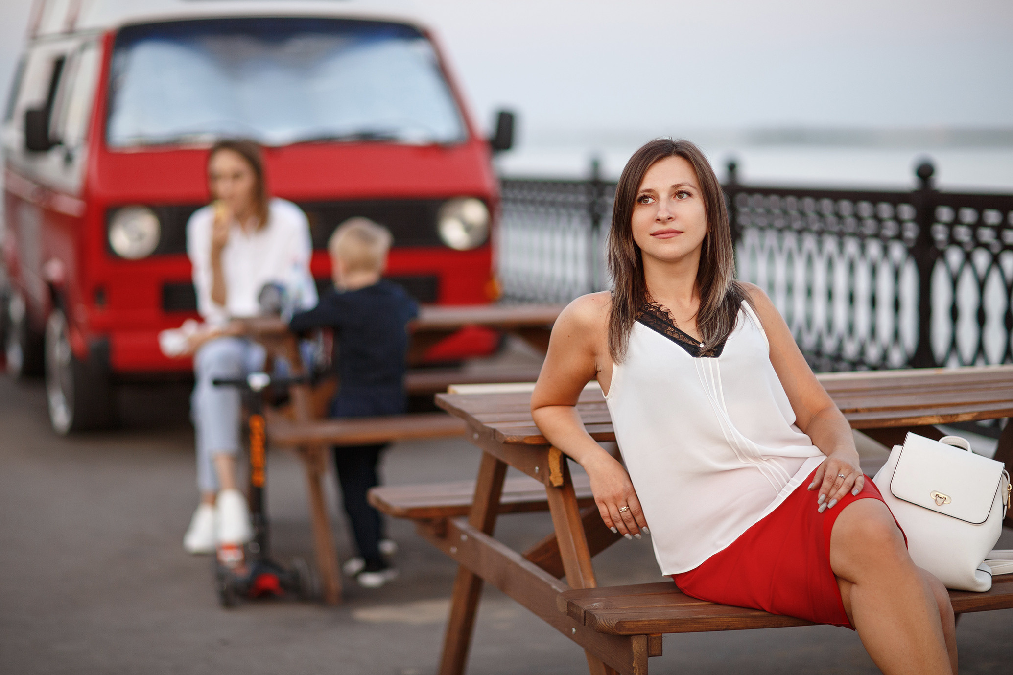 девушка сидит в красной юбке у красного автомобиля