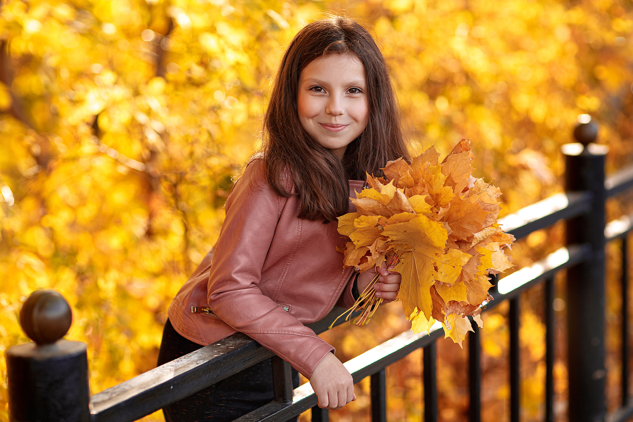 детский портрет девочка с темными волосами в осенних листьях